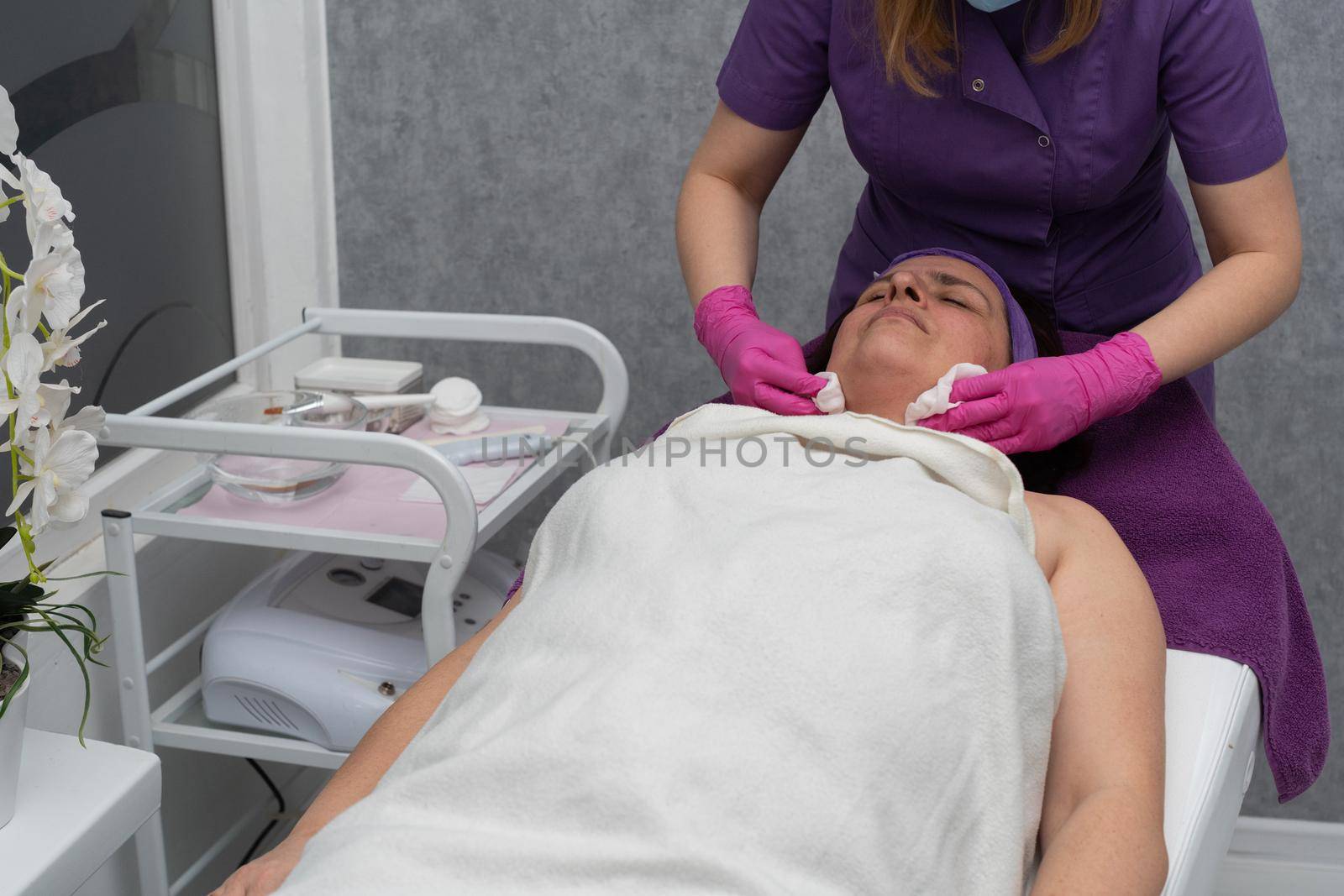 The beautician gently rubs the exfoliating preparation all over the skin of the face