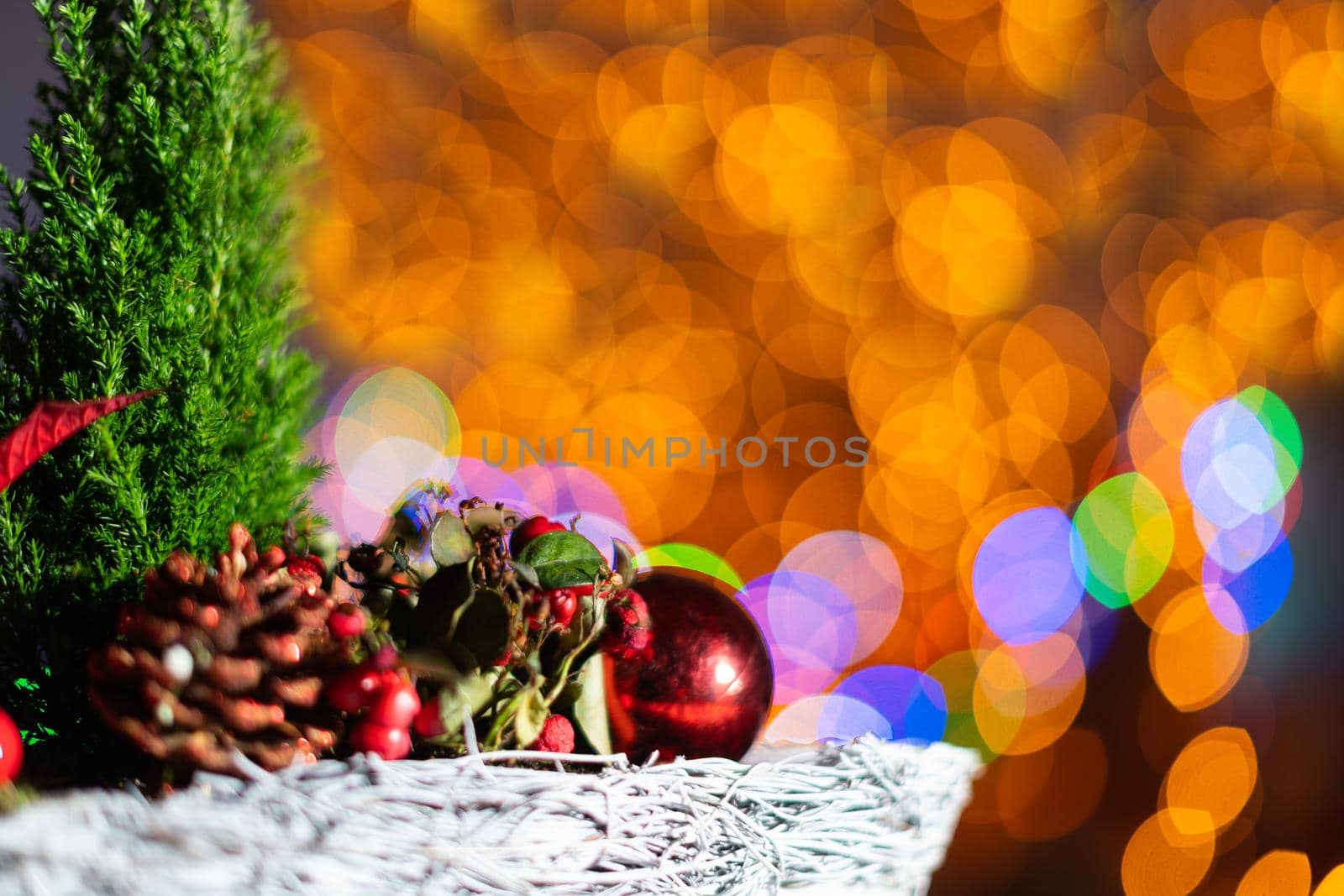 A very close up shot shows a Christmas reed as a decoration for Christmas. In the distance a blurred background created from the bokeh of the glowing Christmas tree lights