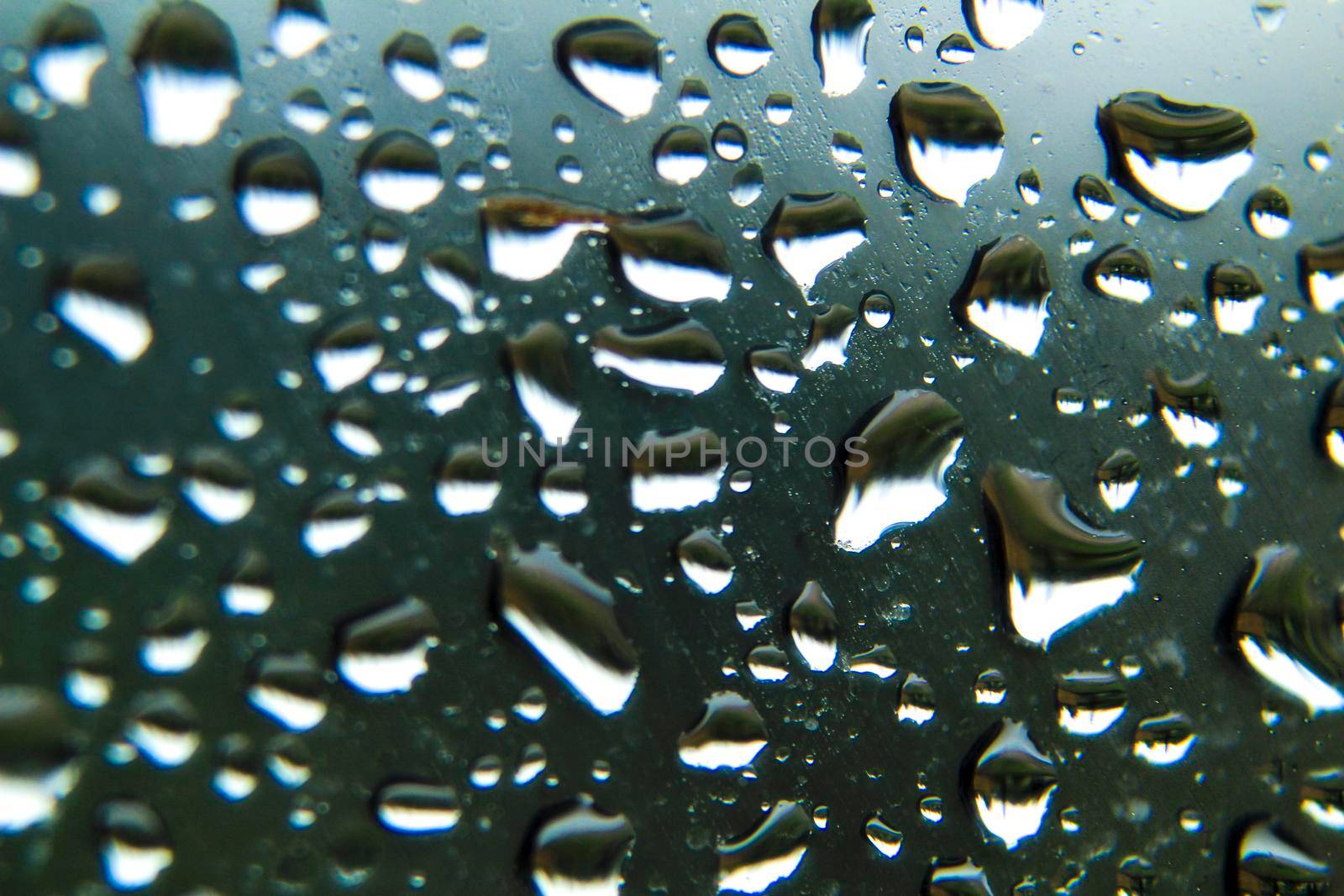 Raindrops on window pane on a cold and cloudy day of winter