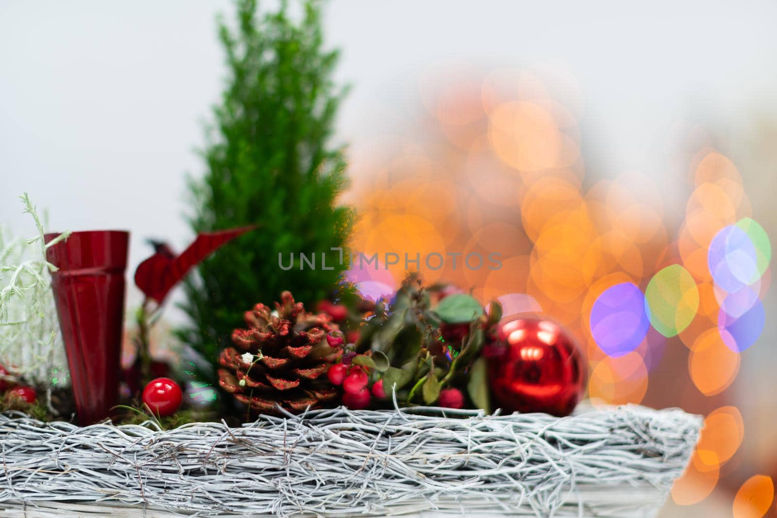 A very close up shot shows a Christmas reed as a decoration for Christmas. In the distance a blurred background created from the bokeh of the glowing Christmas tree lights