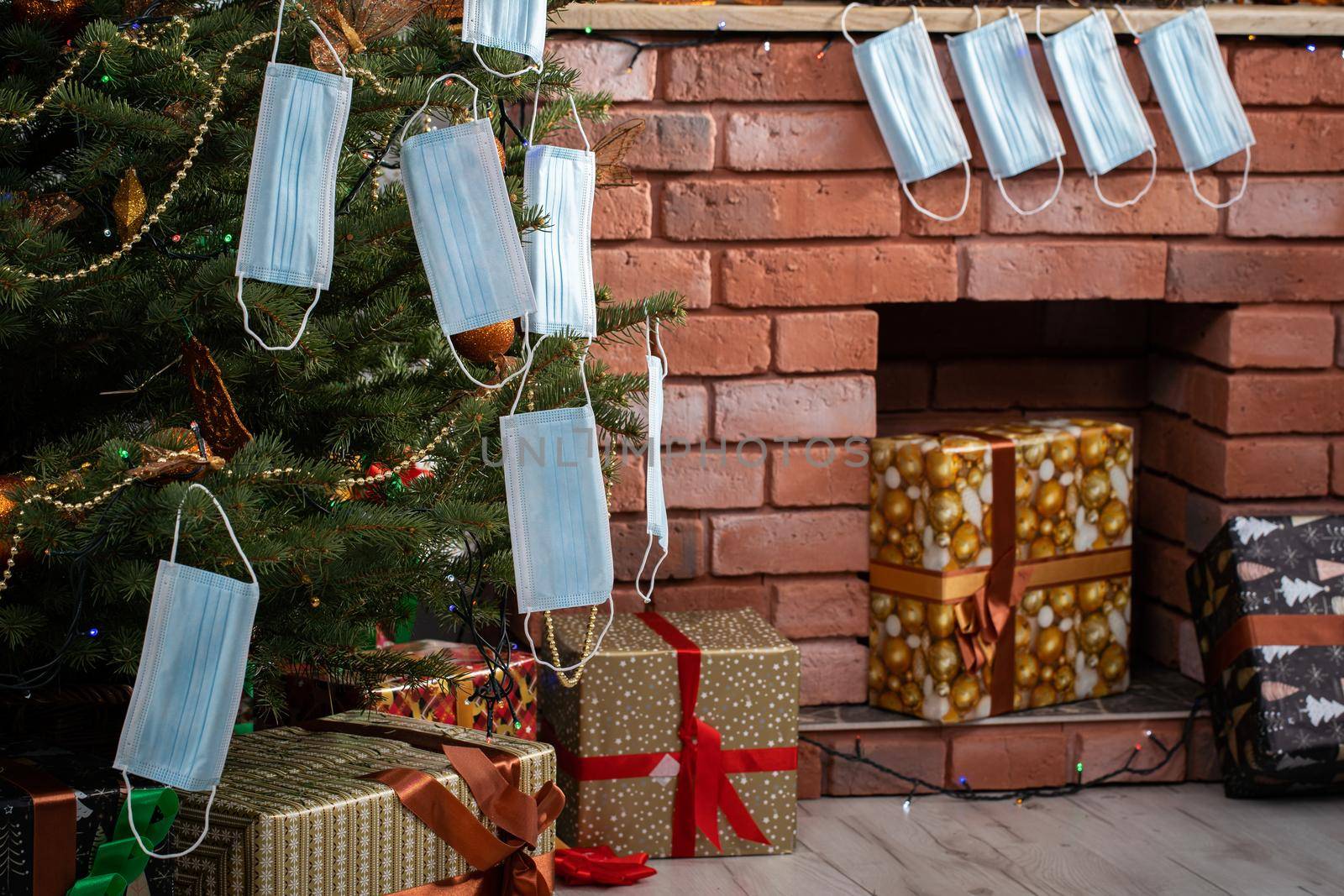 Gifts for the holidays lie under a decorated spruce tree in the large living room of the house. Family holidays despite the global COVID-19 viral disease.