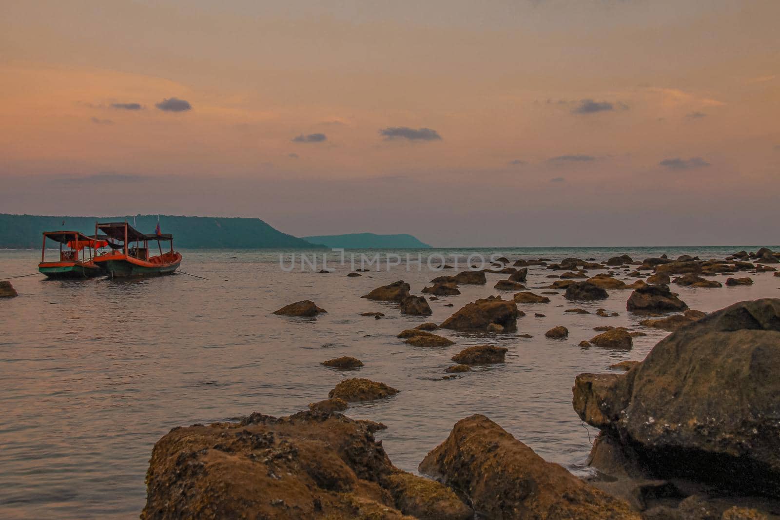 Wide angle view of khmer fishing boats on the rocky beach of Koh Rong Island in Cambodia