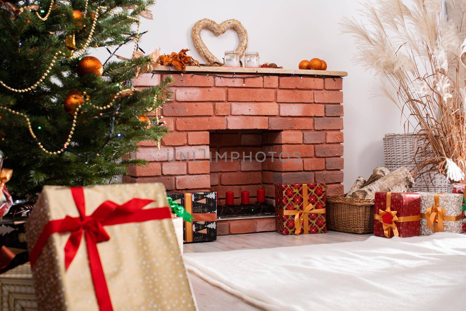 A Christmas tree in the foreground and a decorated fireplace in the second. Unusual Christmas.