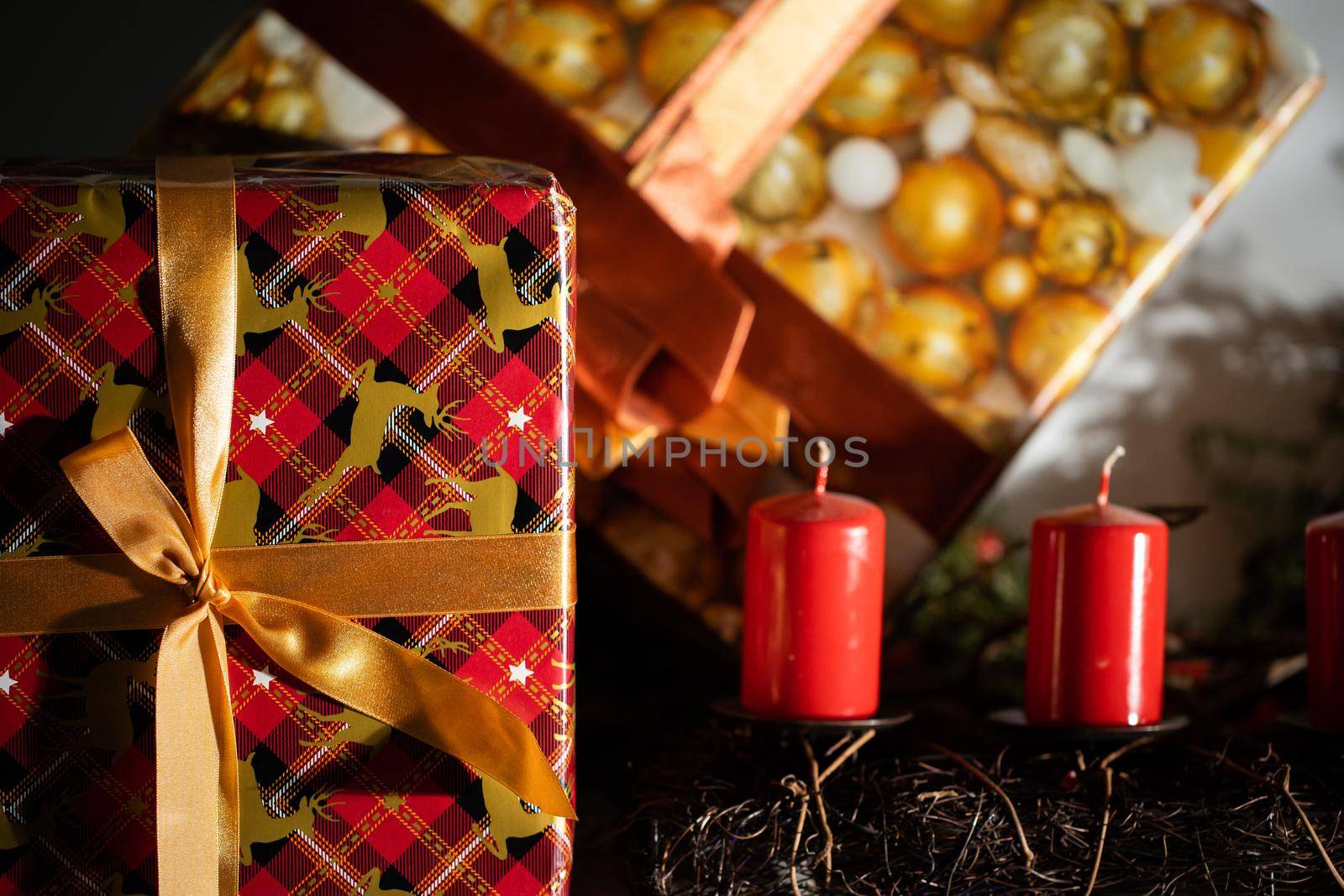 Gift packages. They are lying next to each other. Four red candles. Decoration for Christmas holidays.