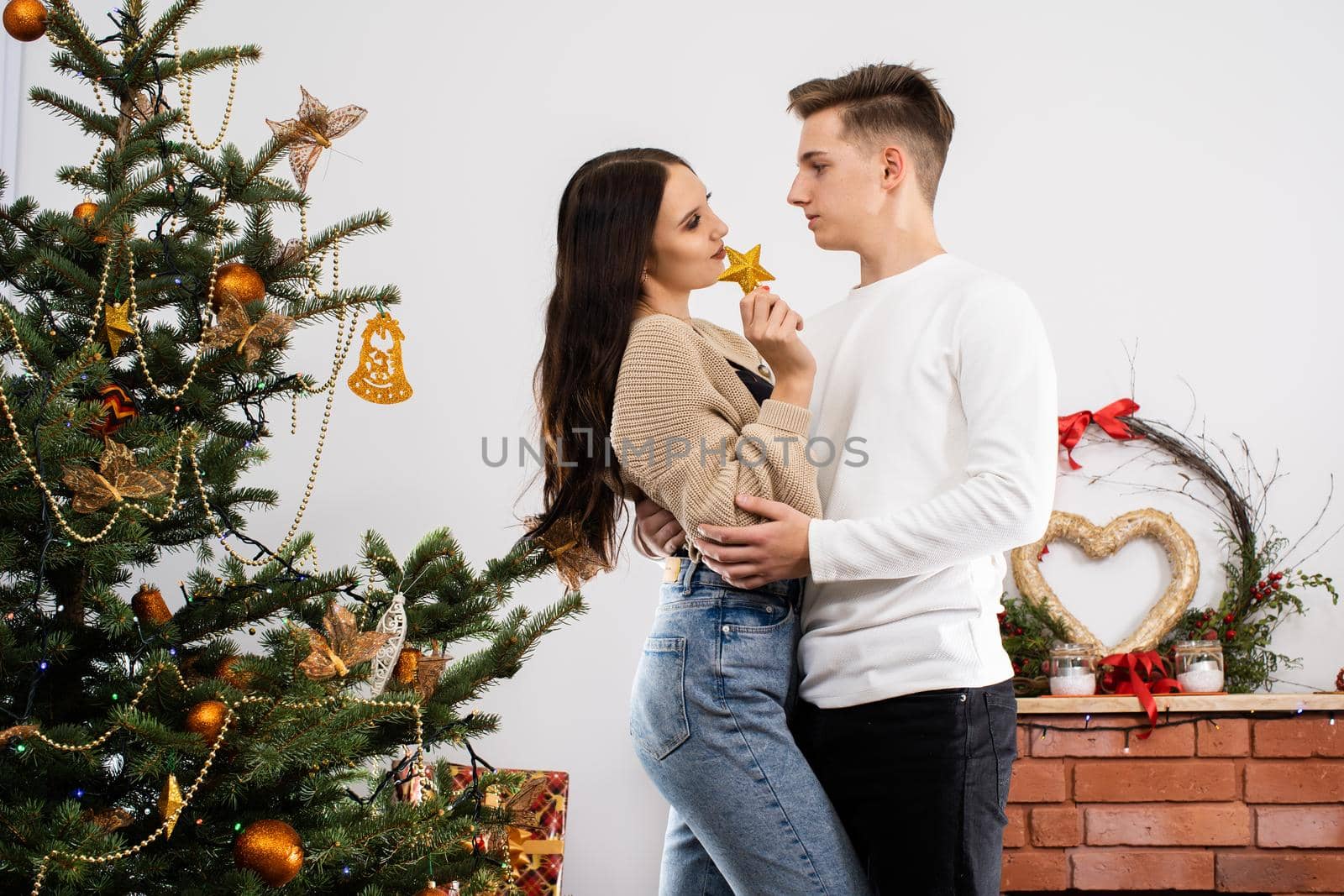 The bride and groom will continue to decorate the Christmas tree. Decoration of a Christmas tree for Christmas in December.