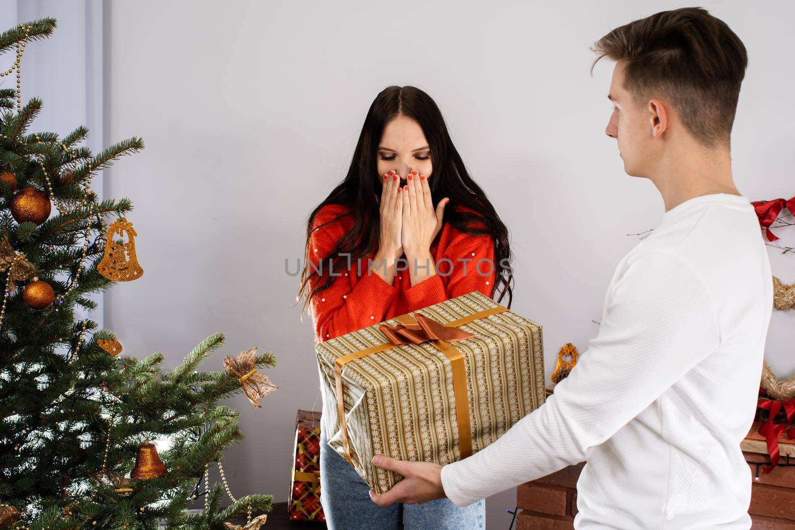 An unexpected gift from the fiancee while decorating the Christmas tree for Christmas. December Christian holidays.