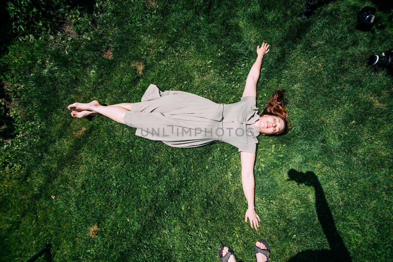 a young girl in the summer lies on the grass.