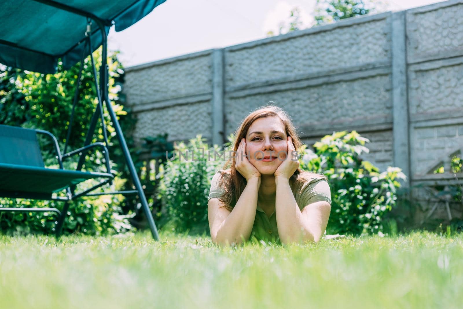 a young girl in the summer lies on the grass.