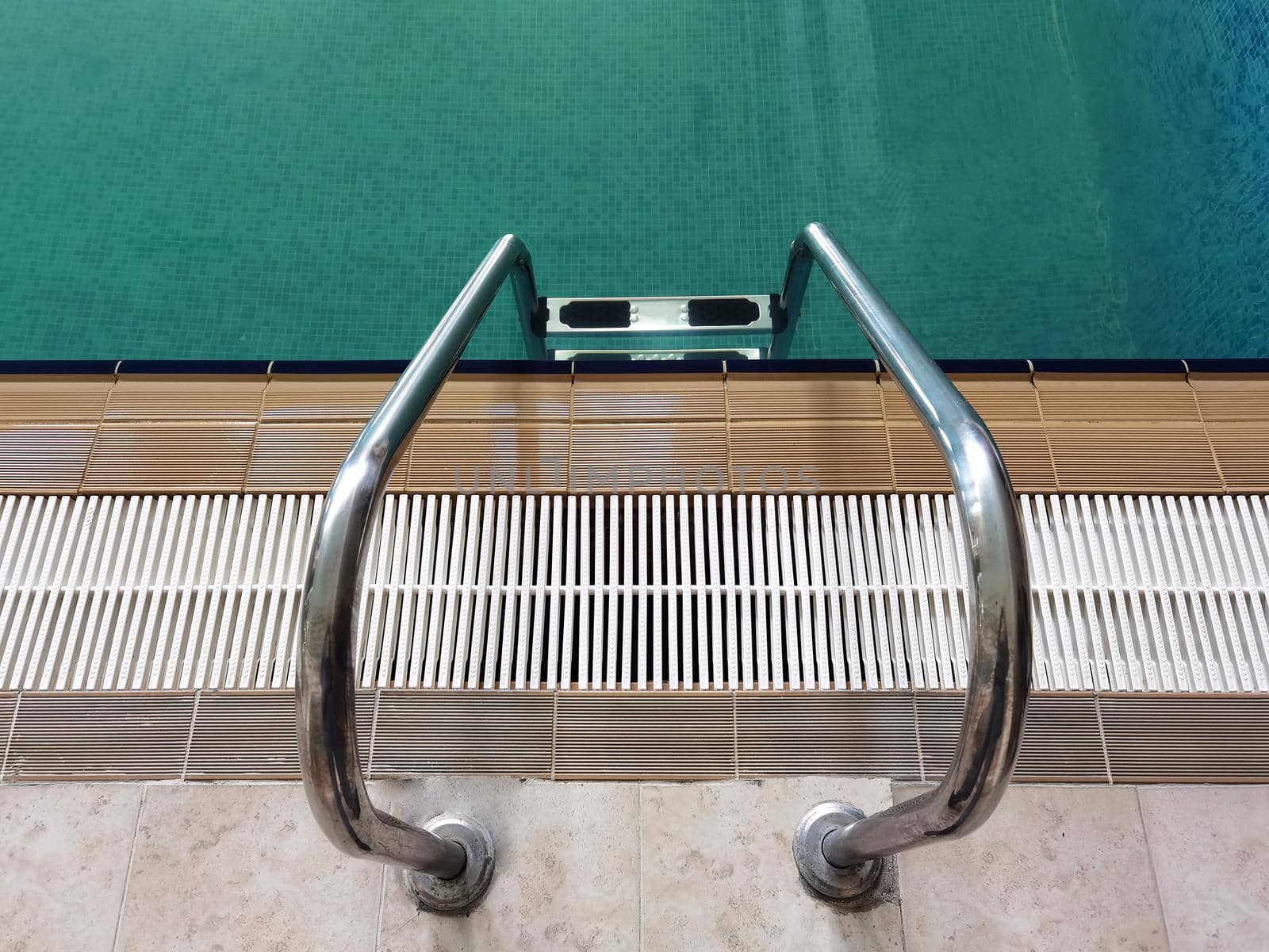 Handrail on pool. Swimming pool with stair at tropical resort. Top view
