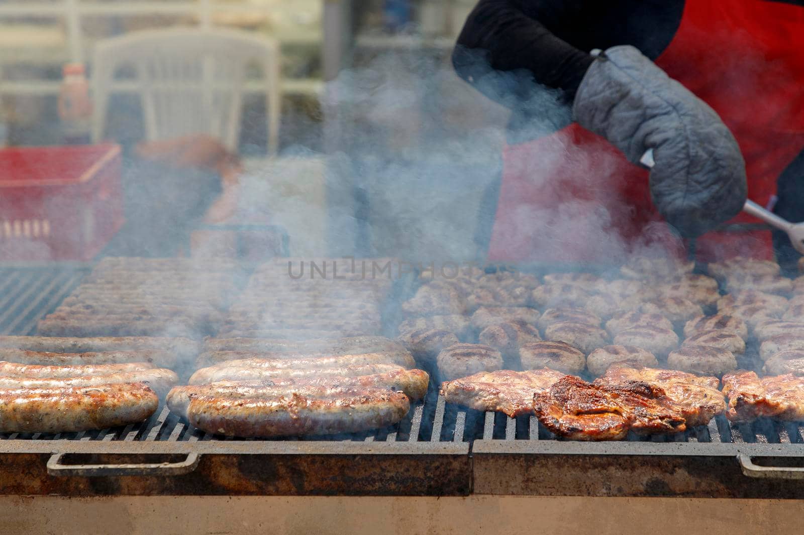 Street food, Meat on a barbecue grill with smoke. Close up by EdVal