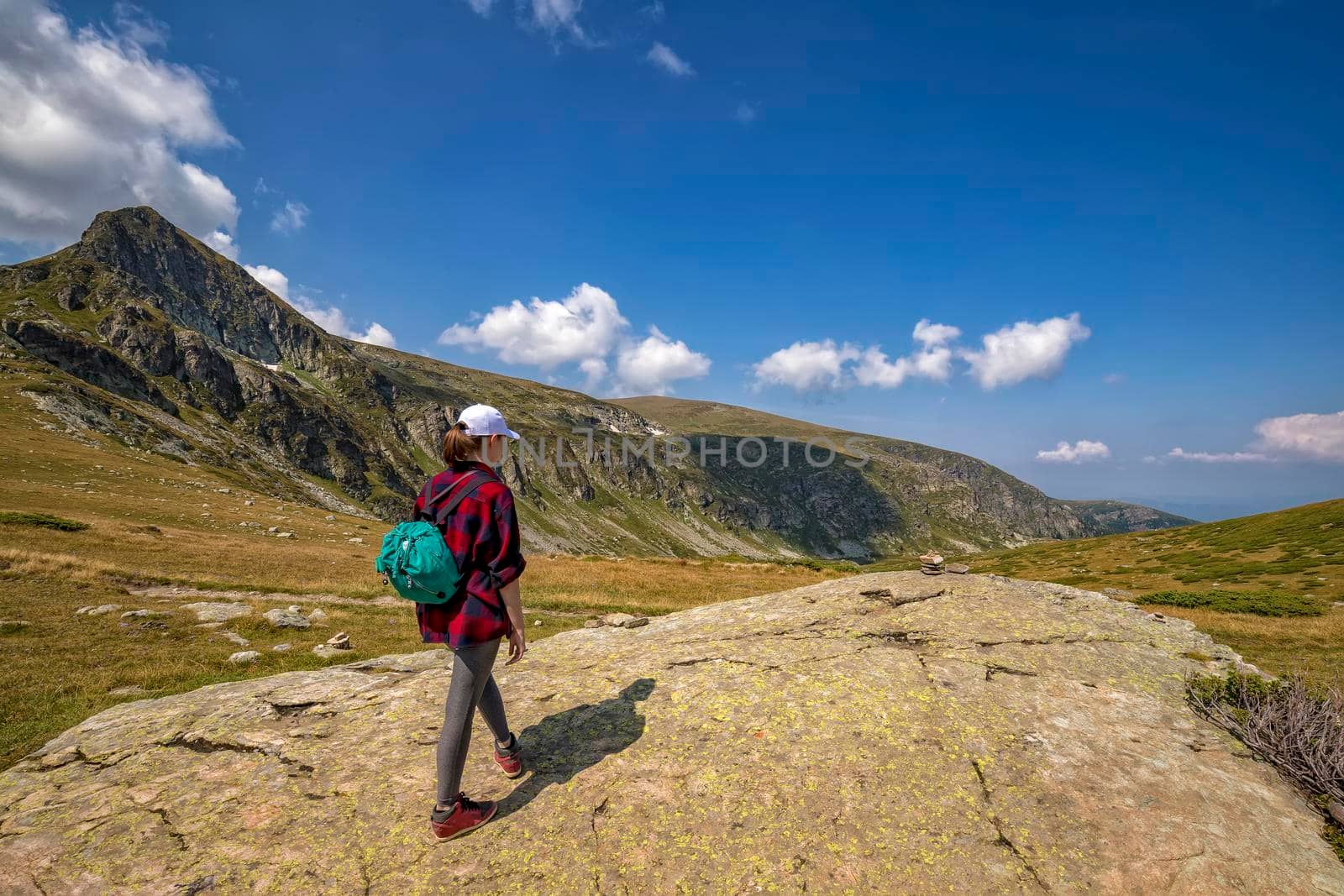 A young girl enjoys a beautiful view. Hiking in the mountains.