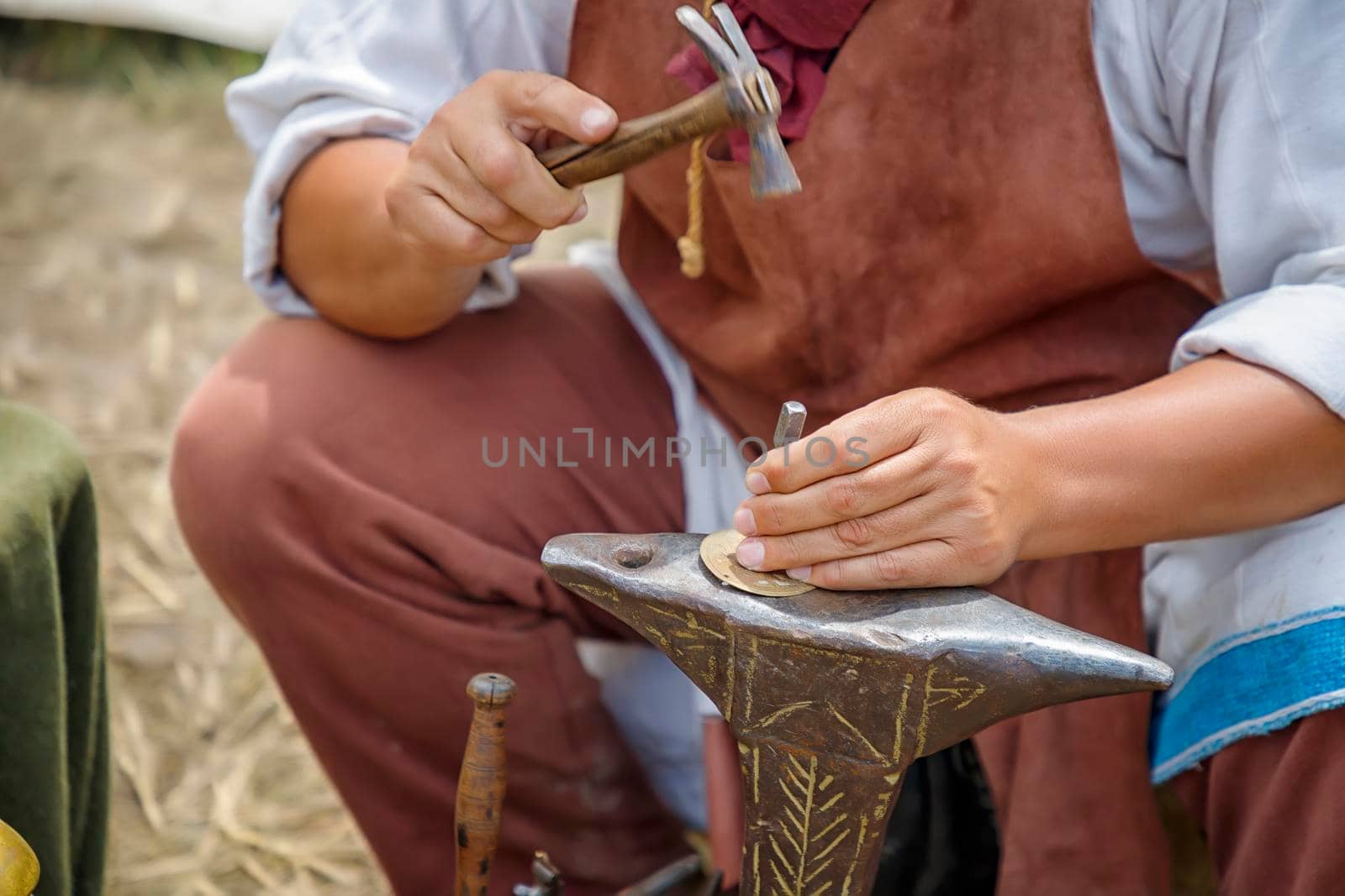 Close up image of the artist at work. He is carefully using a hammer made a decoration by EdVal