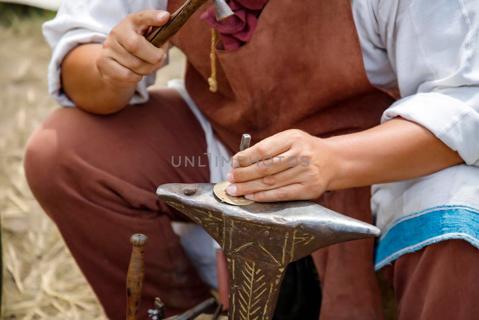 Close up image of the artist at work. He is carefully using a hammer made a decoration by EdVal