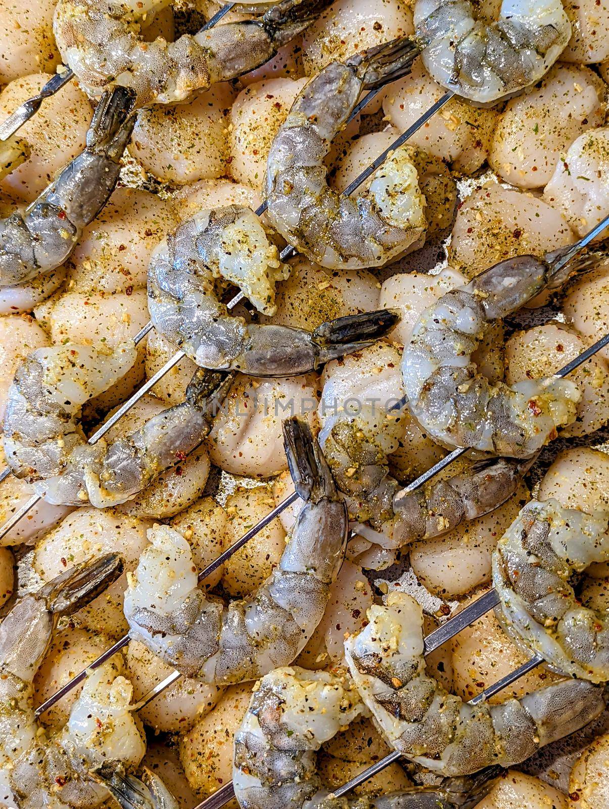 raw seasoned shrimp and scallops ready to grill
