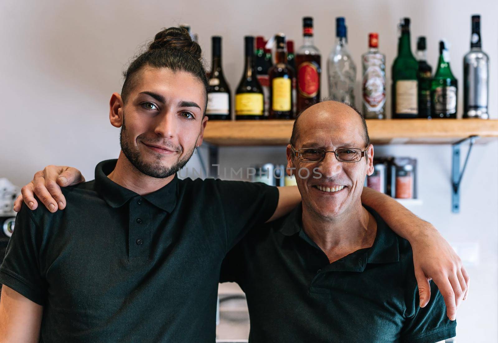 Smiling partners from small companies standing together in their coffee shop. Co-workers looking at the camera. by CatPhotography