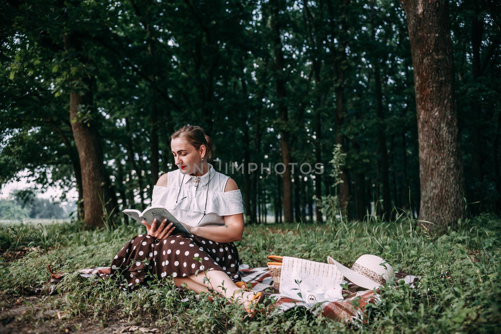 a girl with glasses reads a book in a summer forest. by mosfet_ua