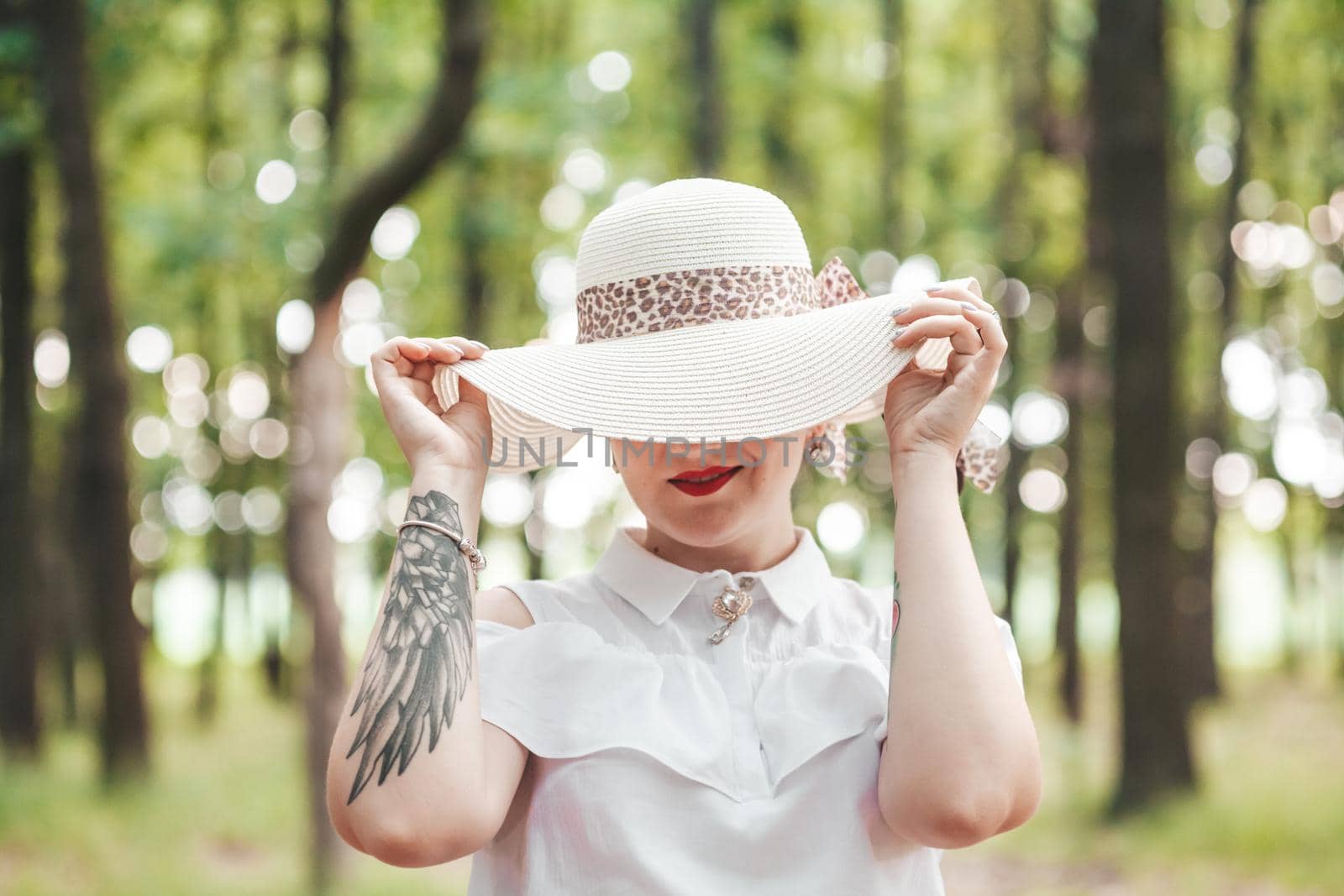 young girl covered her face with a hat, in the woods by mosfet_ua