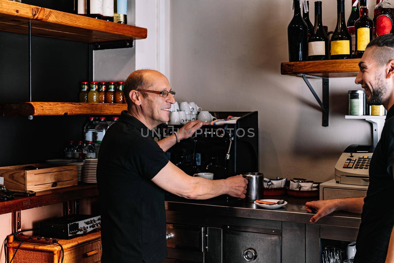 Two waiters working together while talking. Waiter giving an order to his co-worker. by CatPhotography