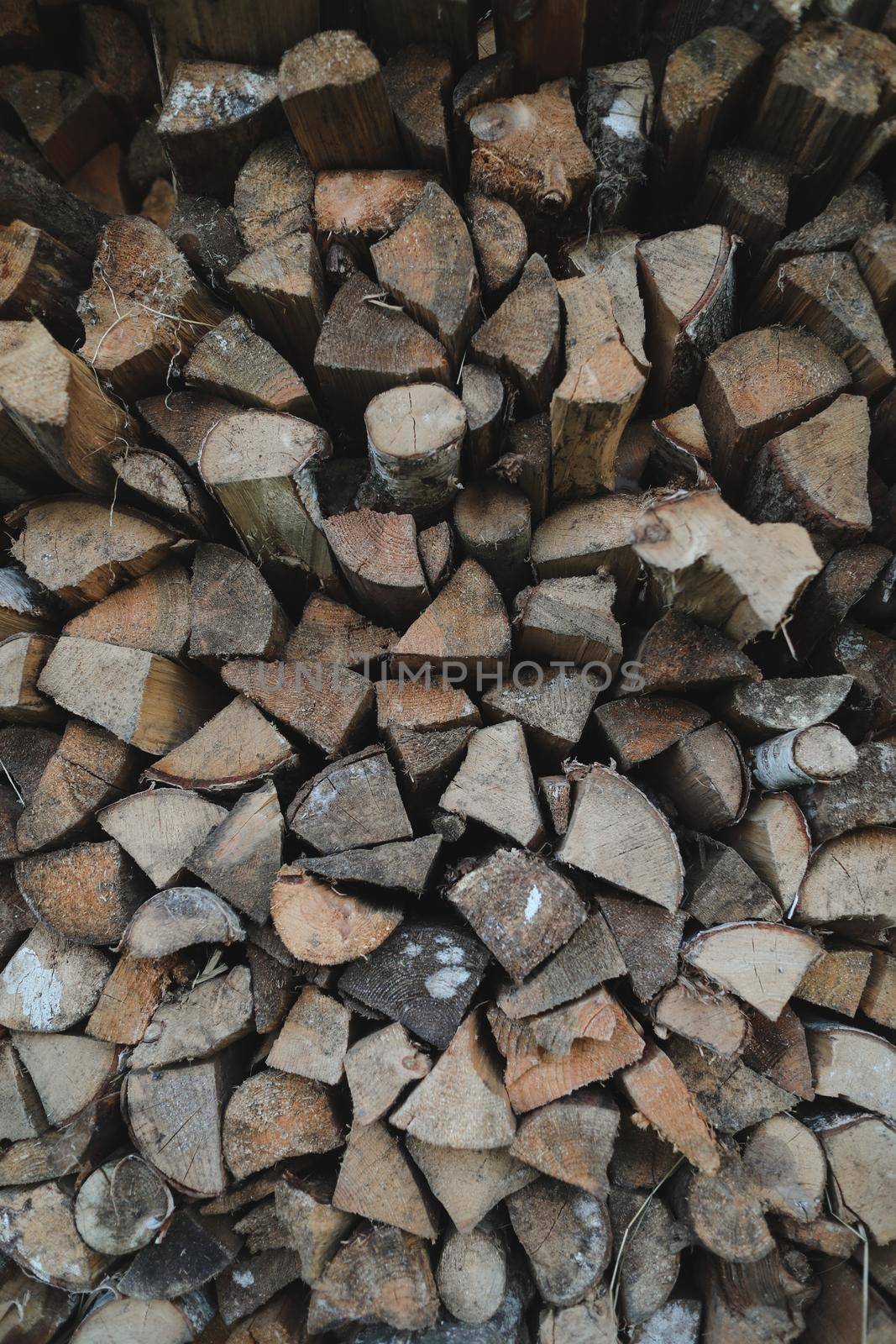 Close up stack of dry firewood oak wooden logs, chopped, split and organized in a pile for winter fuel stock, low angle