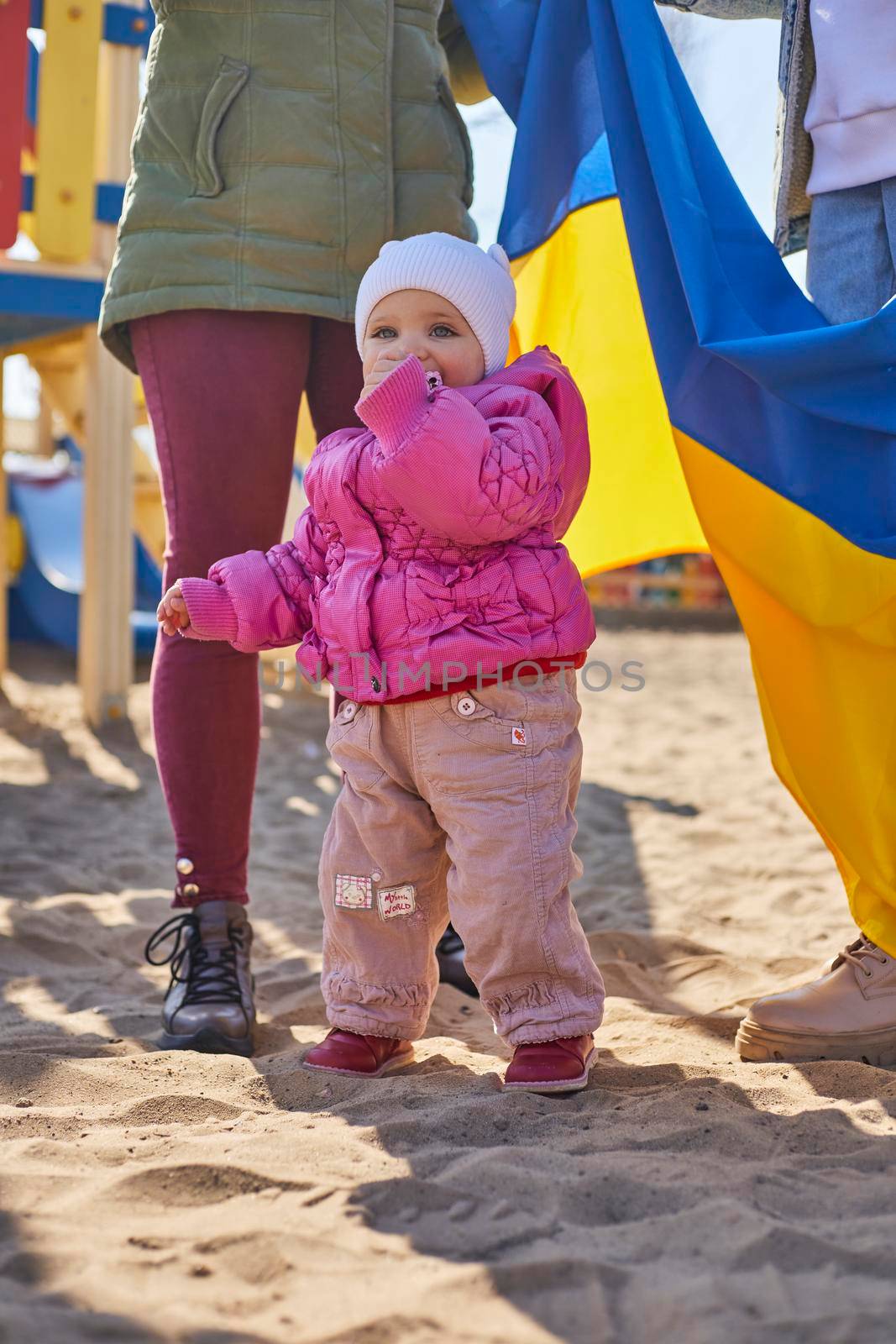 Portrait of a joyful Ukrainian woman holding a child and a Ukrainian flag. The girl is waiting for her husband from the war. War between Russia and Ukraine