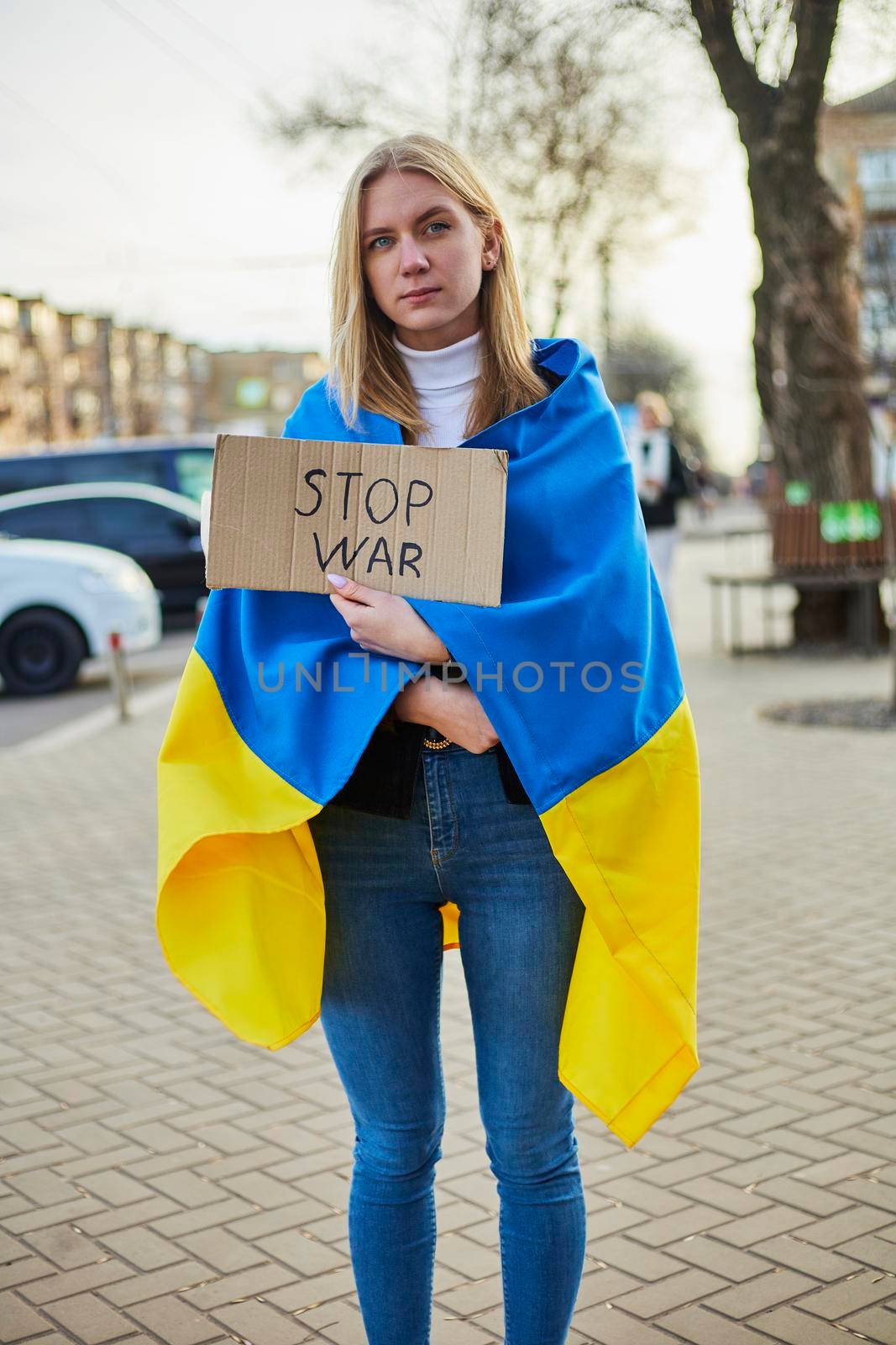 Portrait of a joyful Ukrainian woman holding a Ukrainian flag and a sign. The girl is waiting for her husband from the war. War between Russia and Ukraine. by mosfet_ua