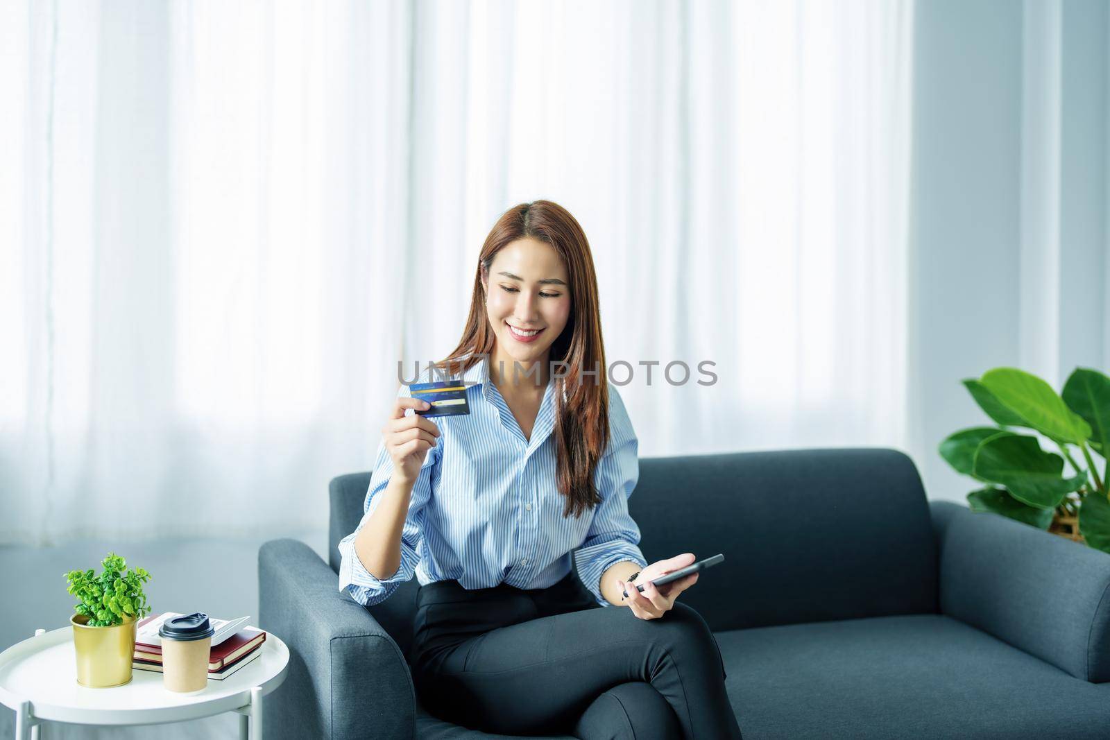 Online Shopping and Internet Payments, Portrait of Asian woman are using their credit cards and to smart mobile phones shop online or conduct errands in the digital world. by Manastrong