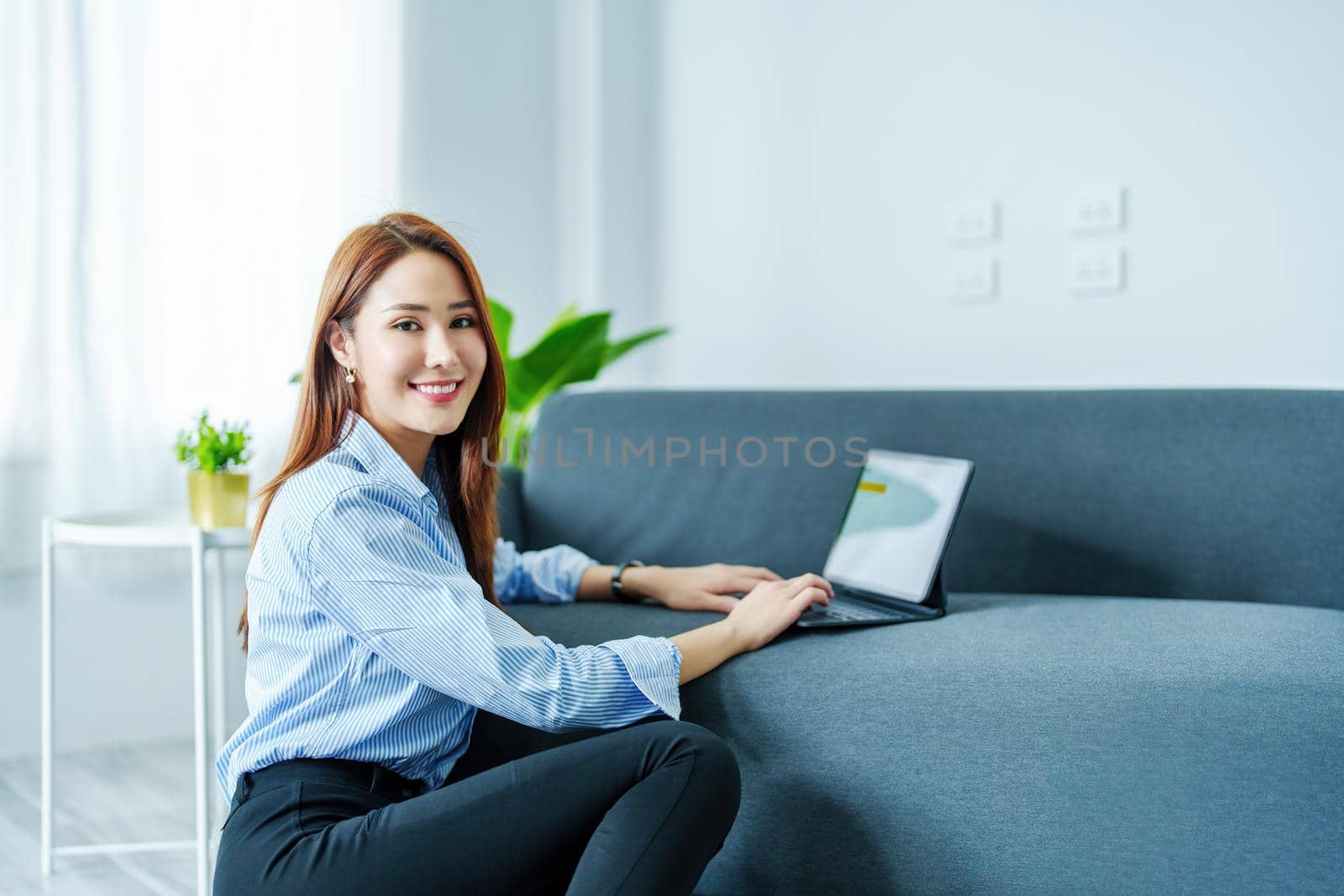 internet learning, online shopping, selling, meeting, information searching, Portrait of young Asian woman showing smiling face while using tablet to work at home. by Manastrong