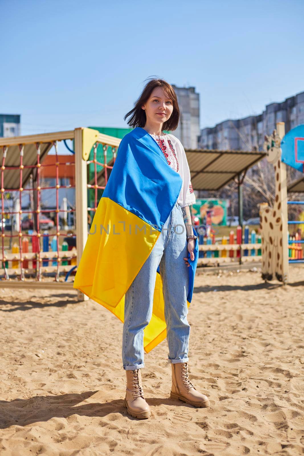 Portrait of a joyful Ukrainian woman holding a child and a Ukrainian flag. The girl is waiting for her husband from the war. War between Russia and Ukraine. by mosfet_ua