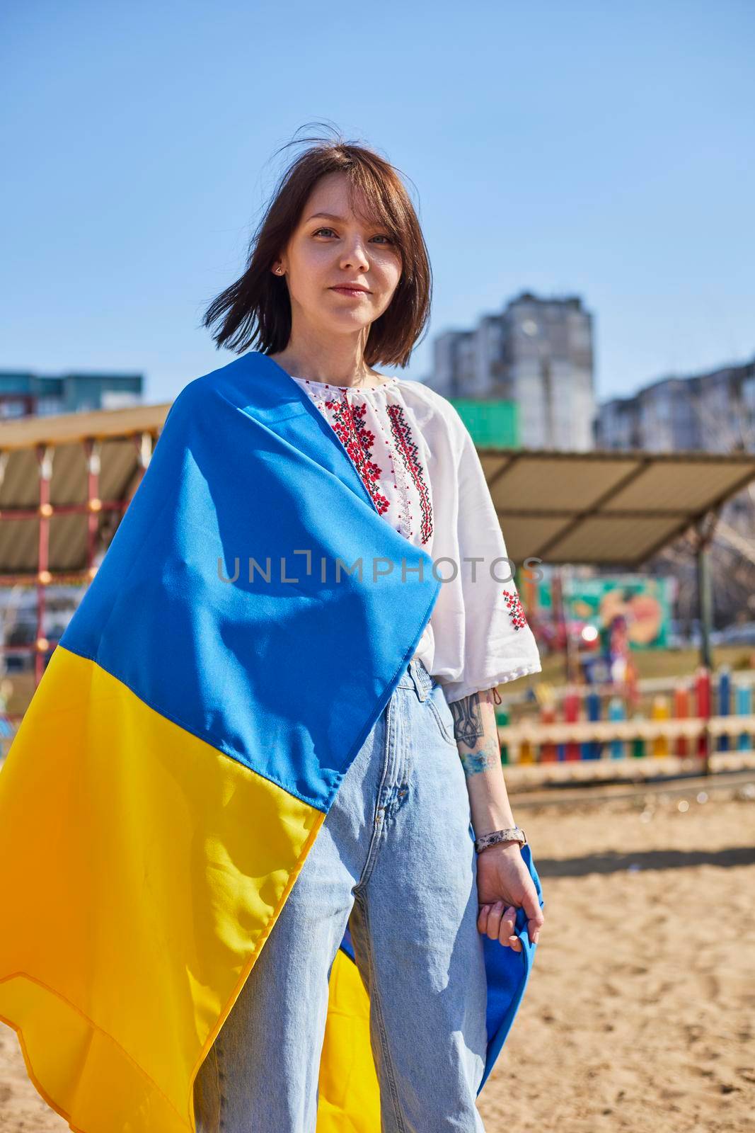 Portrait of a joyful Ukrainian woman holding a child and a Ukrainian flag. The girl is waiting for her husband from the war. War between Russia and Ukraine. by mosfet_ua