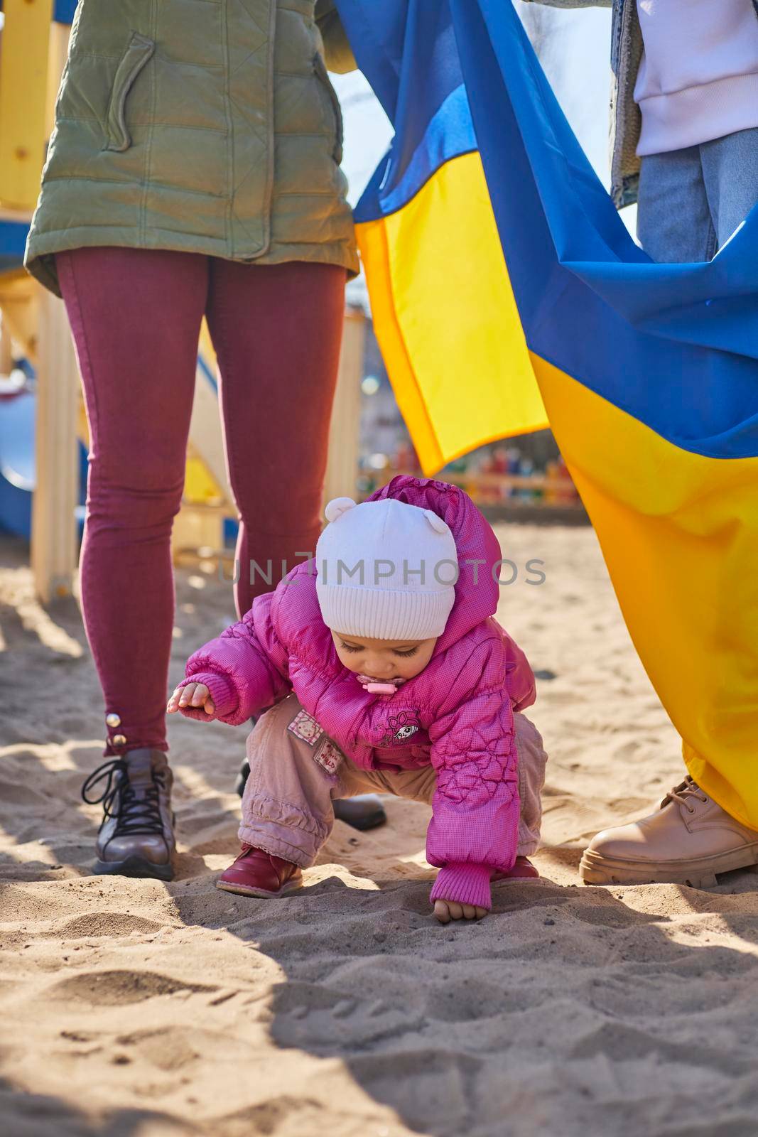 Portrait of a joyful Ukrainian woman holding a child and a Ukrainian flag. The girl is waiting for her husband from the war. War between Russia and Ukraine. by mosfet_ua