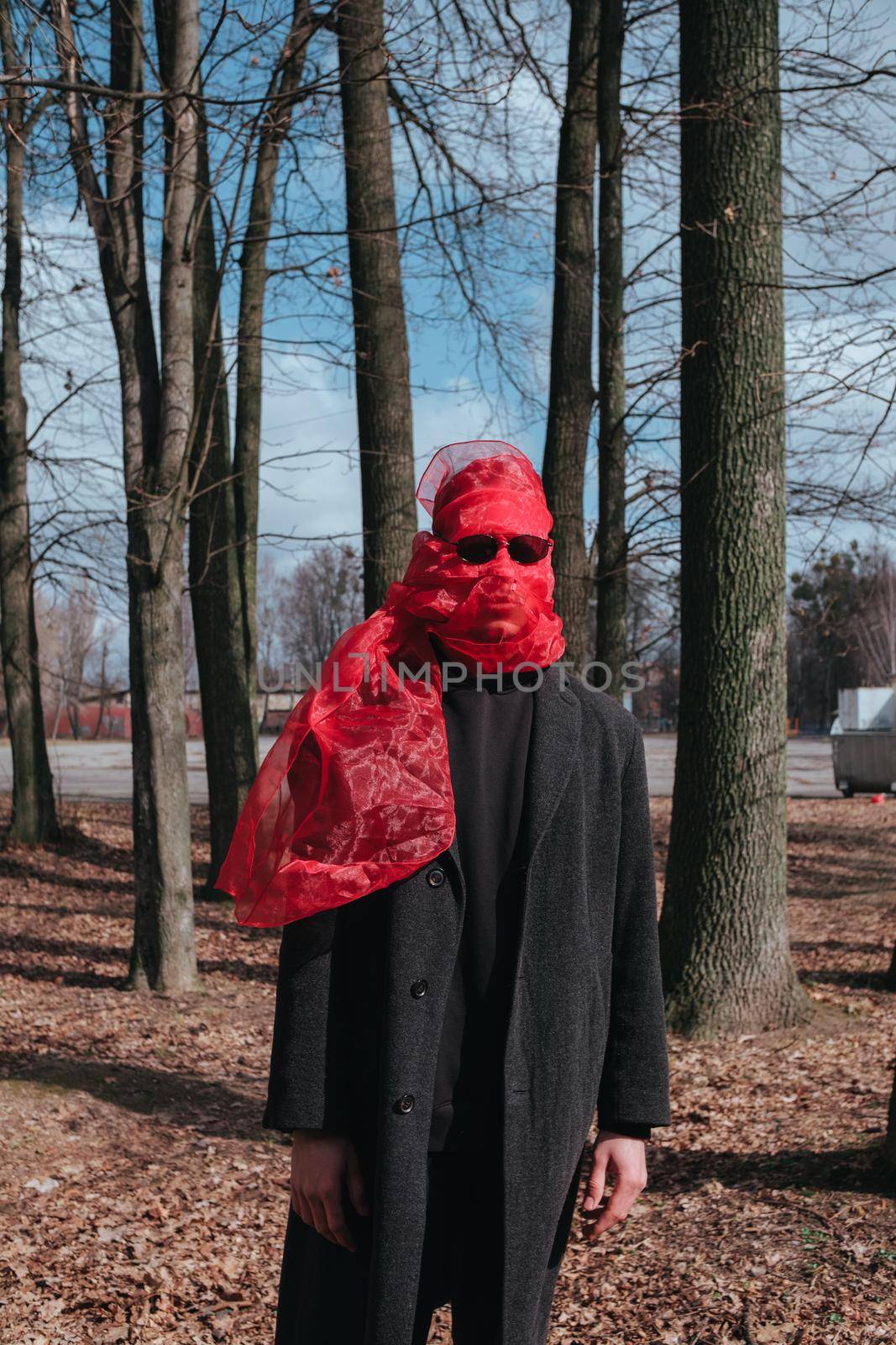 Superhero man with red mask and sunglasses fashion fighter in the park