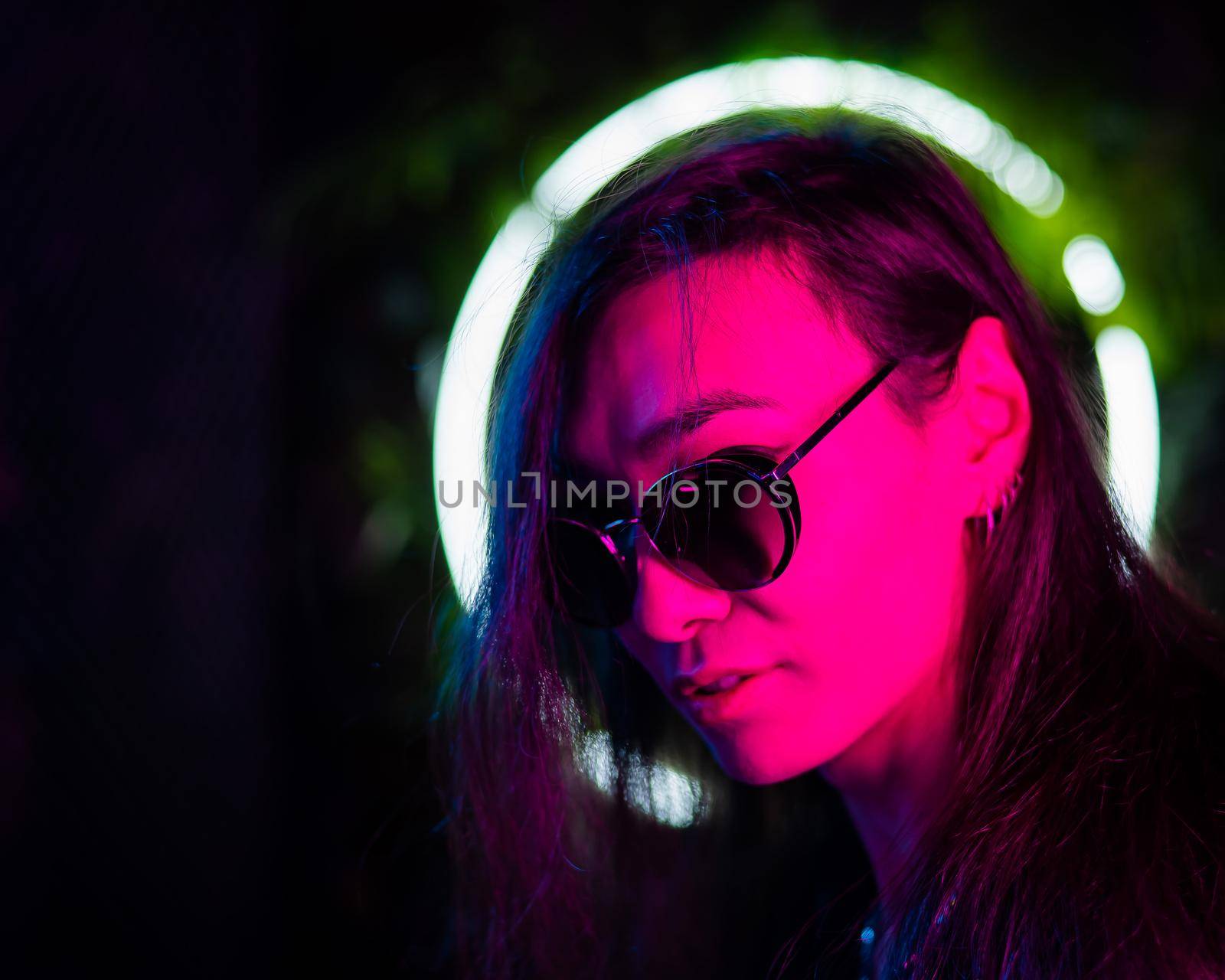 Portrait of asian man wearing sunglasses in neon light. by mrwed54