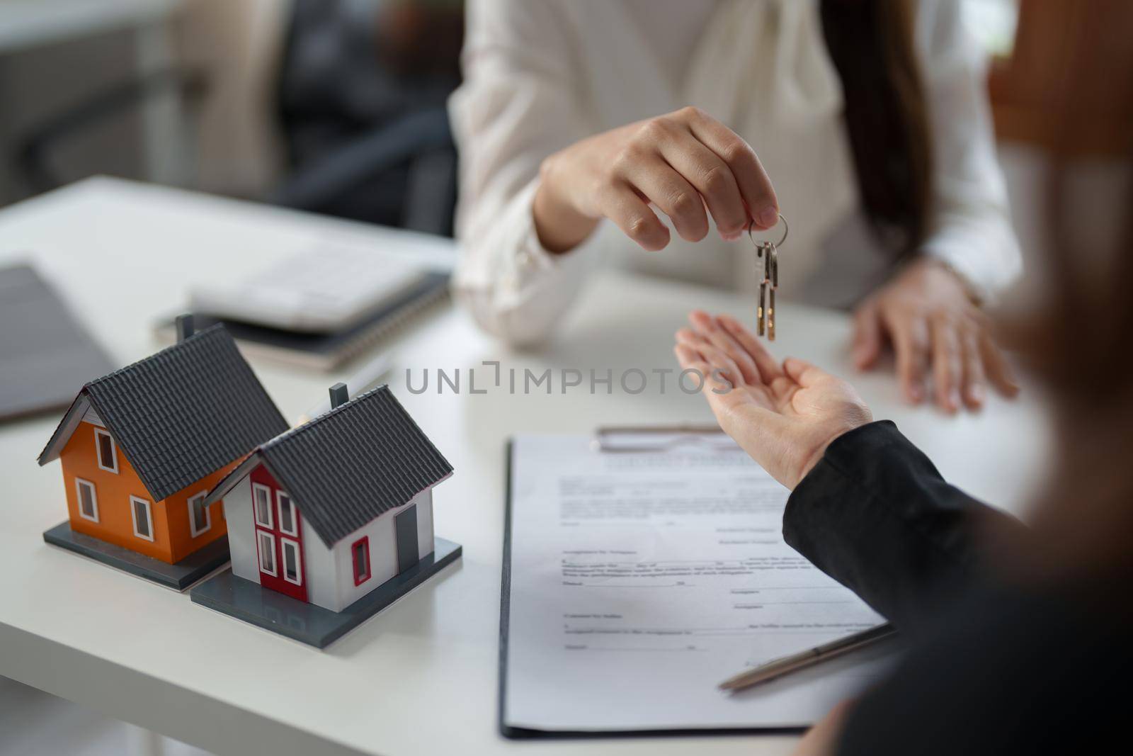 Real estate agent give key house for customer after sign agreement contract signature for buy or sell house. Real estate concept contact agreement concept.
