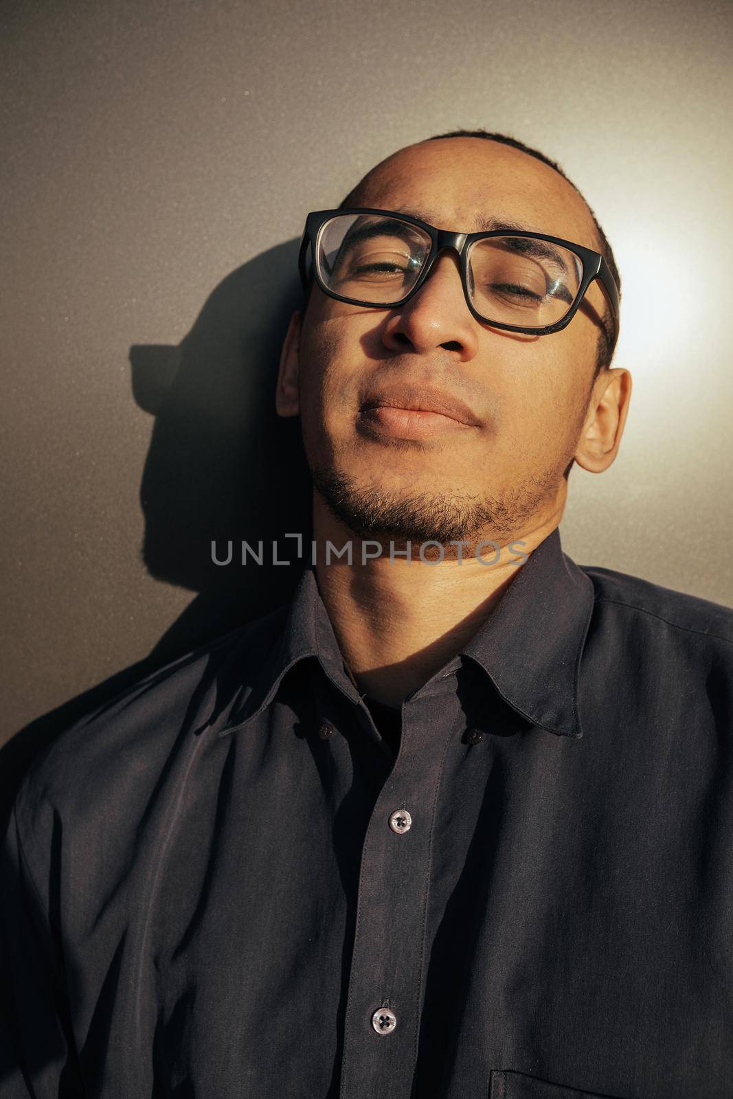 Portrait angry man screaming in studio. Closeup african american guy shouting on black background. Male model aggressive face expression. Serious man take off sunglasses. Displeased customer client