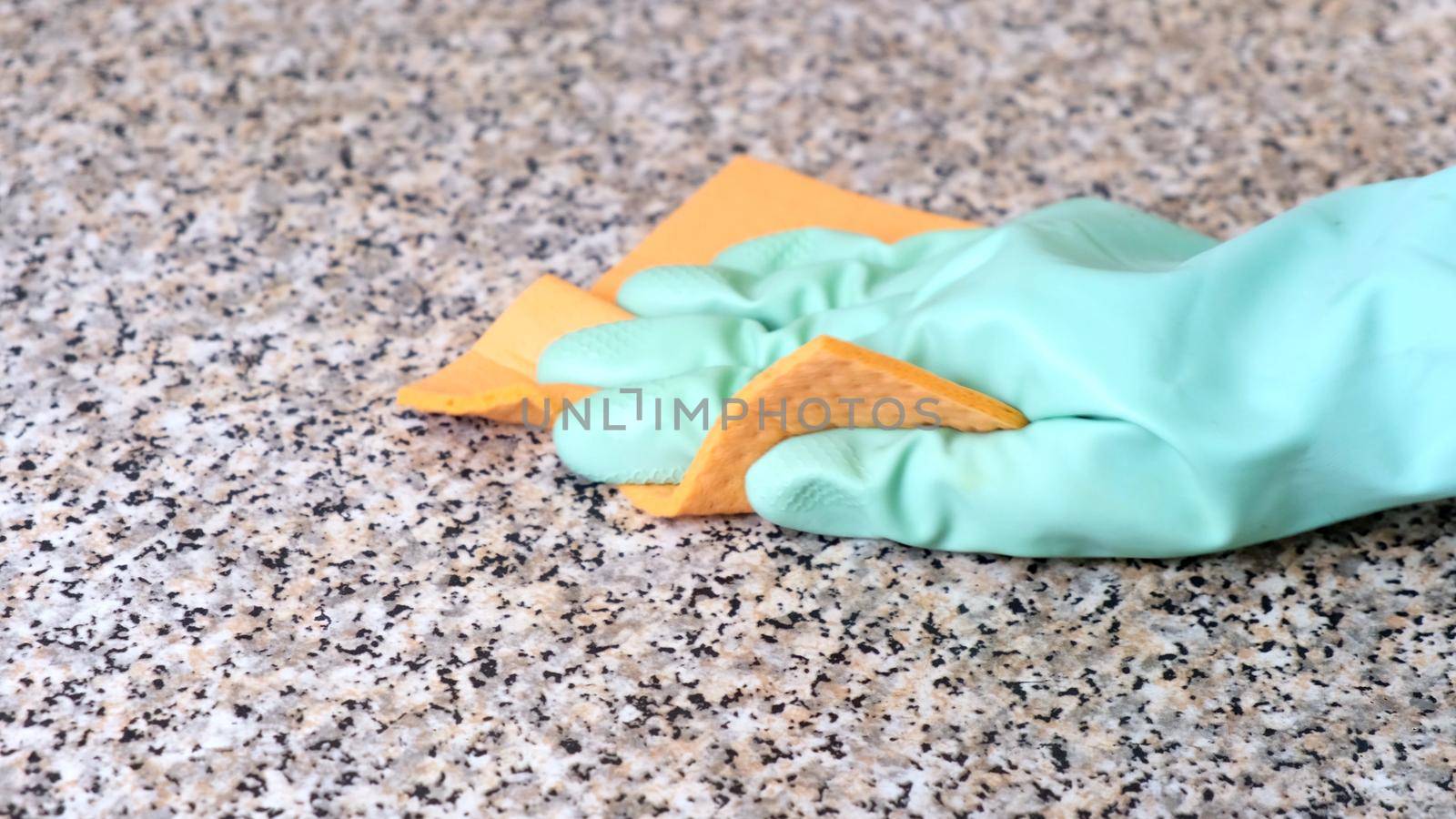 Hand Cleaning Kitchen Work Surface with Rubber Gloves and Disinfectant Spray. The concept of cleaning, help around the house.