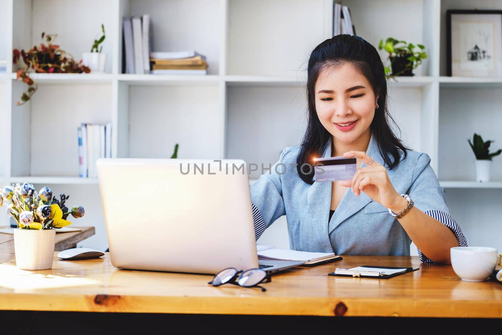 Online Shopping and Internet Payments, Portrait of Asian woman are using their credit cards and laptop computer to shop online or conduct errands in the digital world