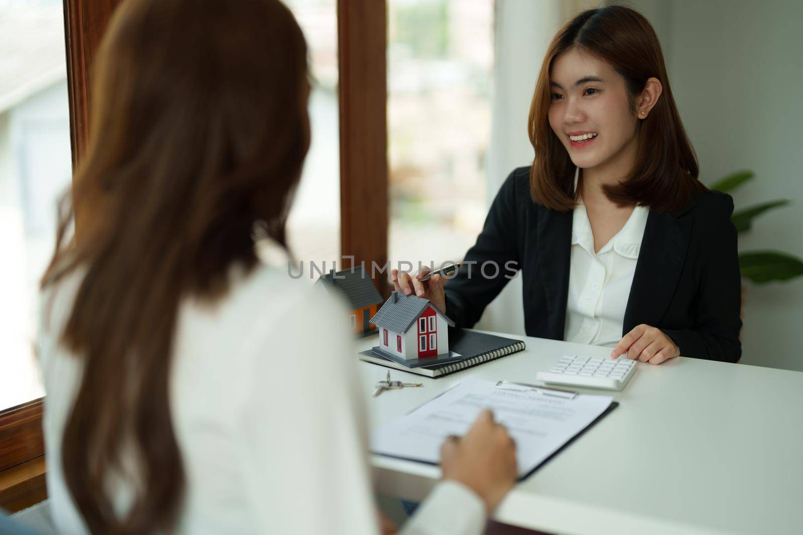 Real estate agent or bank officer describes the loan interest to the customer with home purchase contracts or on office loans and interest rates.