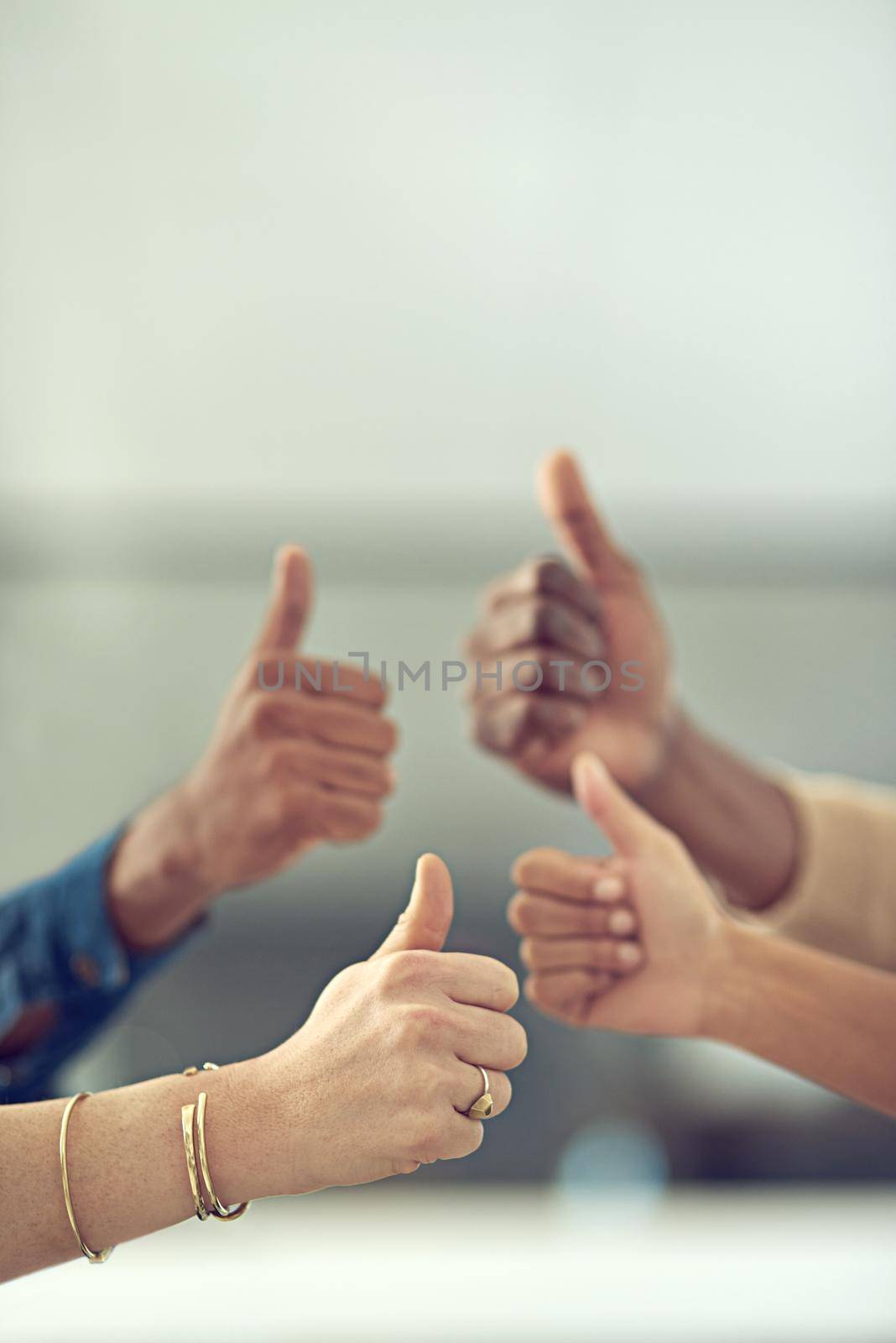 Youre doing great. Closeup shot of a group of businesspeople giving thumbs up together. by YuriArcurs