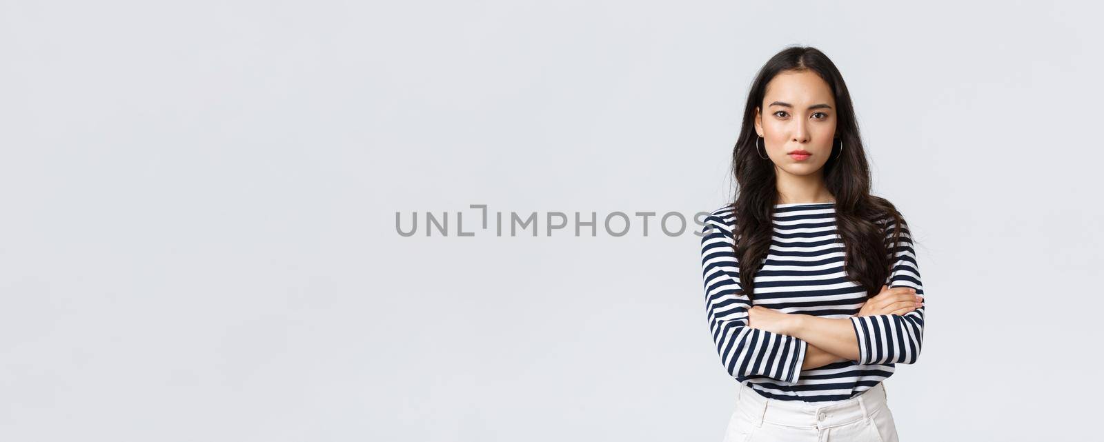 Lifestyle, people emotions and casual concept. Angry disappointed woman cant forgive betrayal, cross hands over chest and looking dismay and dislike camera, standing upset.