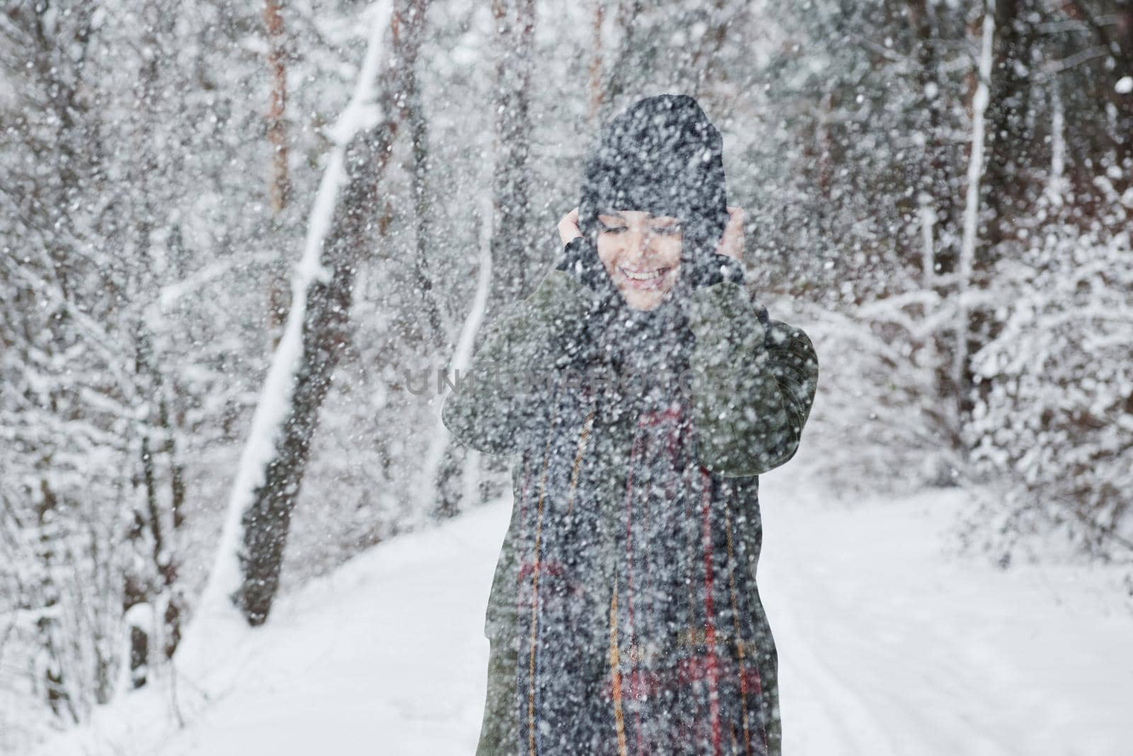 It's cold but awesome to be there. Cheerful young girl in warm clothes have a walk in the winter forest at daytime by Standret