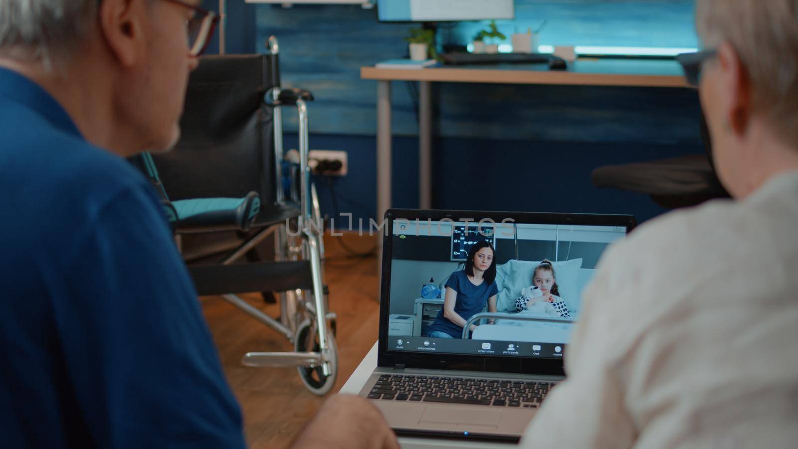 Grandparents talking to family in hospital on online conference, using laptop to talk about health care. Elder couple attending videoconference on internet connection. Remote communication