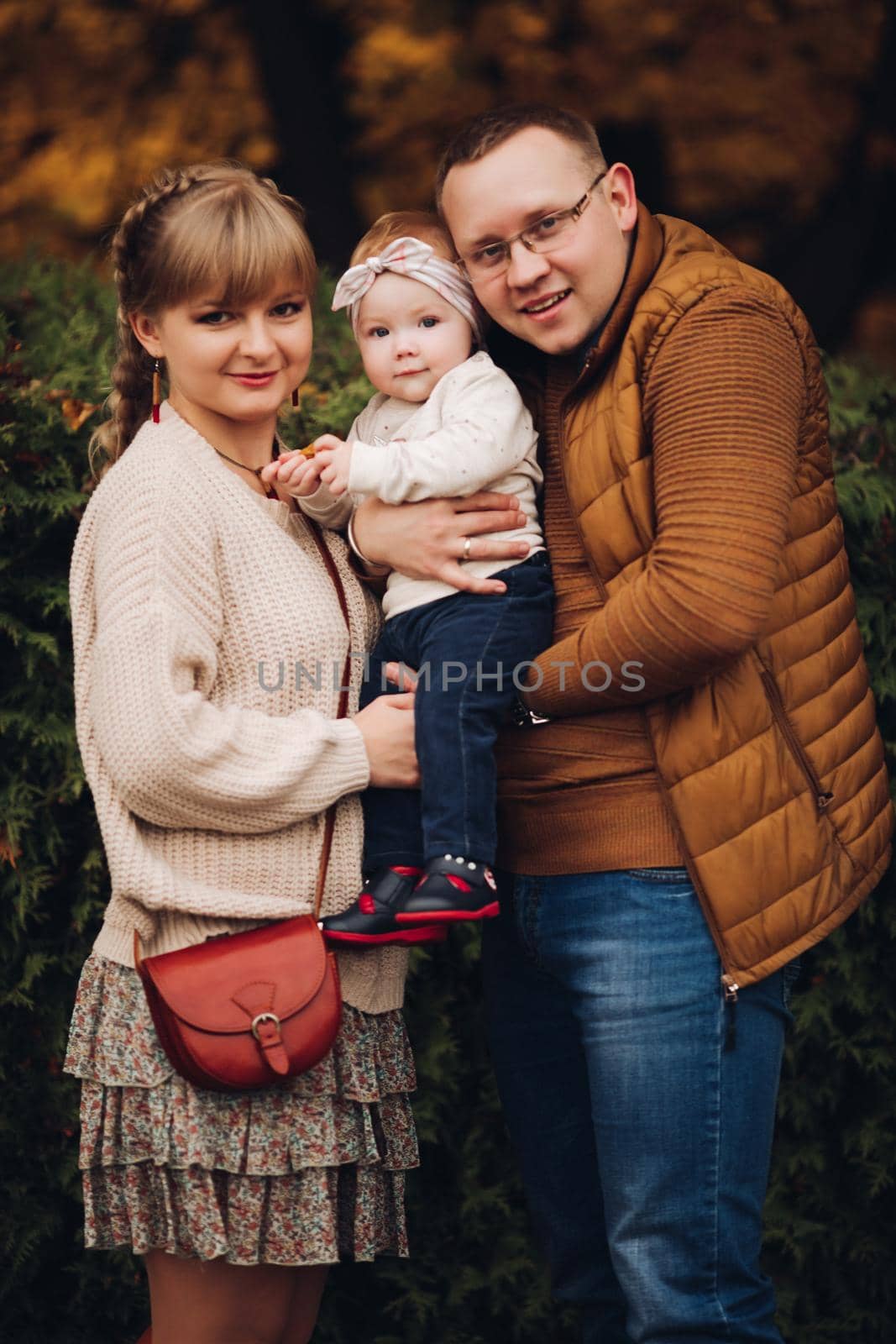 Beautiful and happy family with little child in park. by StudioLucky