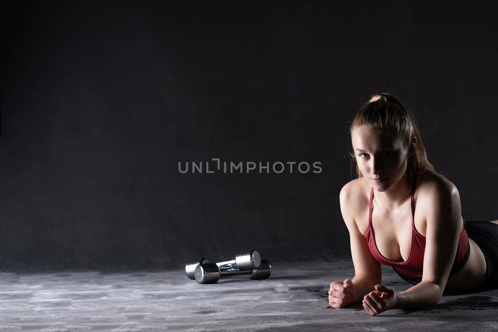 Stands a dumbbells with the the girl plank on in floor push-ups looks like a kira knightley girl plank empty space gym fit for lifestyle from active athlete, dumbbell beautiful. Slim sweat