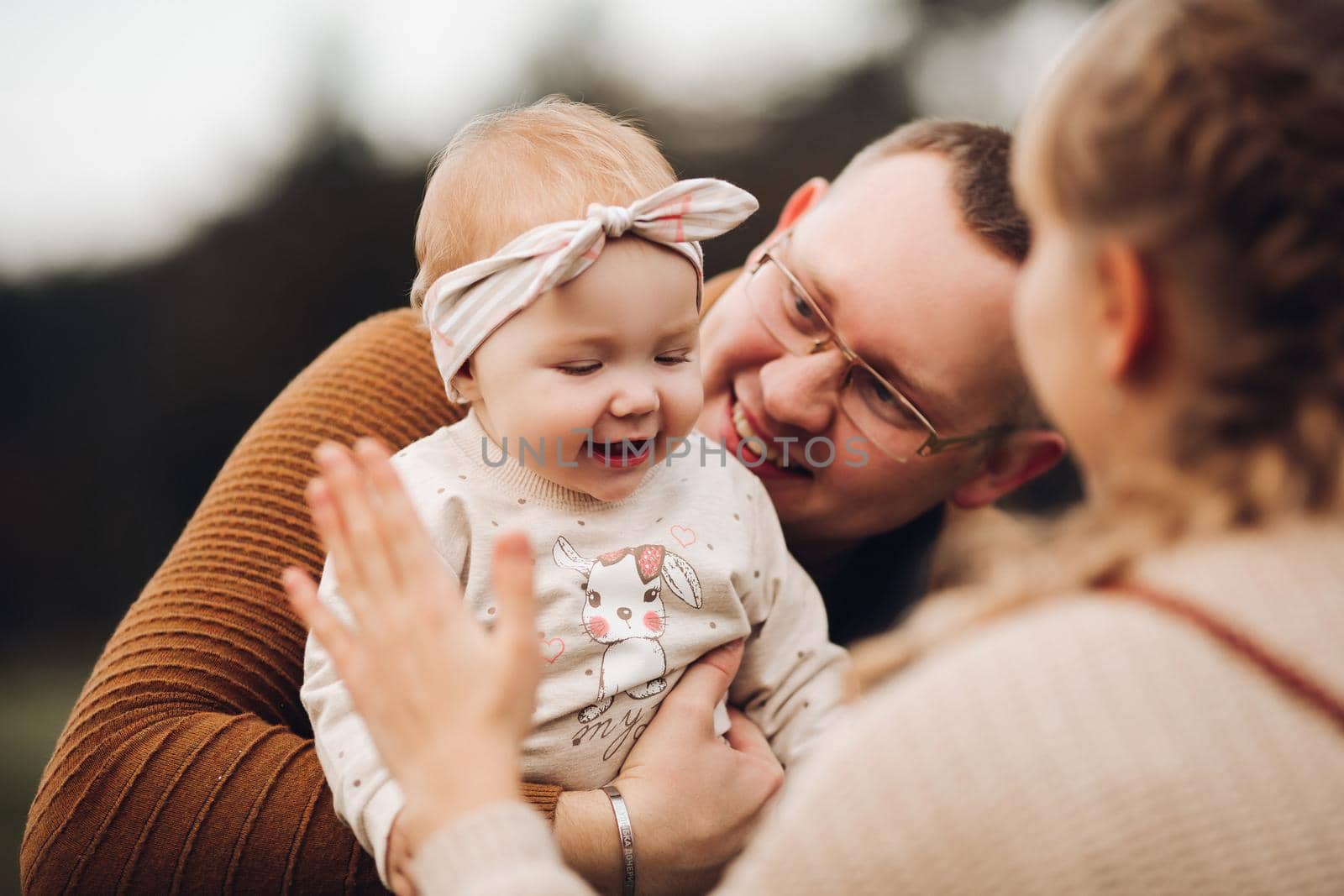 Beautiful and happy family with little child in park. by StudioLucky