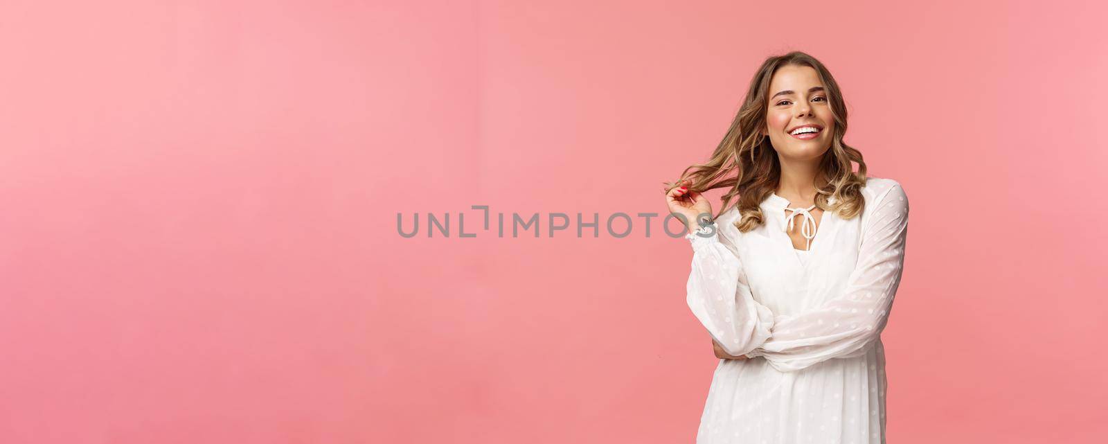 Beautiful and confident blond young 20s woman in stylish white cute dress, touching hair and smiling satisfied, getting dressed for romantic date, concept of women and beauty, pink background by Benzoix