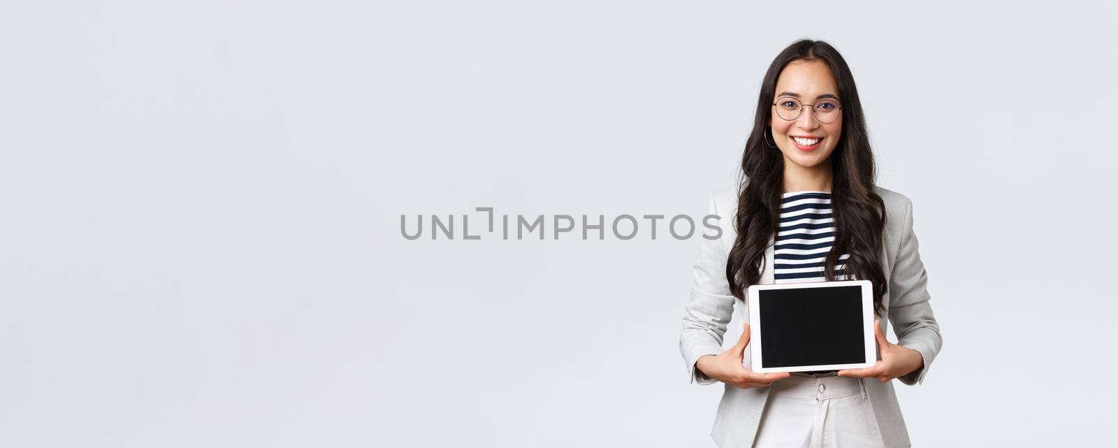Business, finance and employment, female successful entrepreneurs concept. Friendly smiling real estate broker showing best deal to clients on digital tablet display, working with customers.