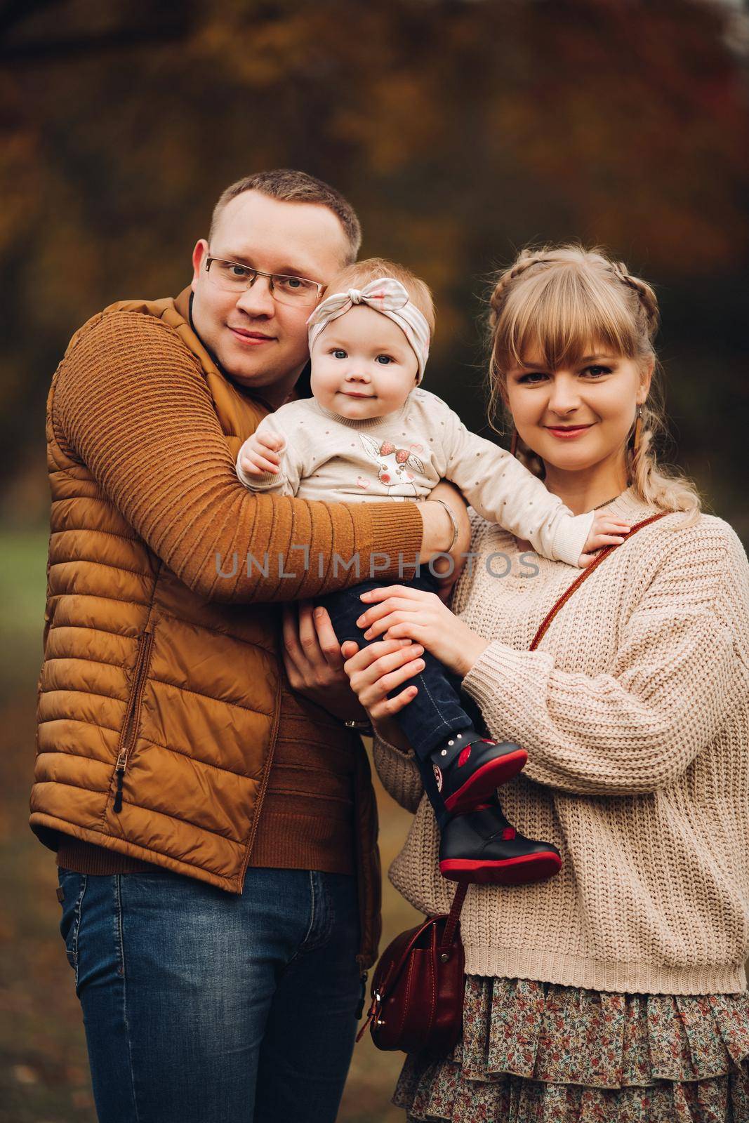 Beautiful and happy family with little child in park. by StudioLucky