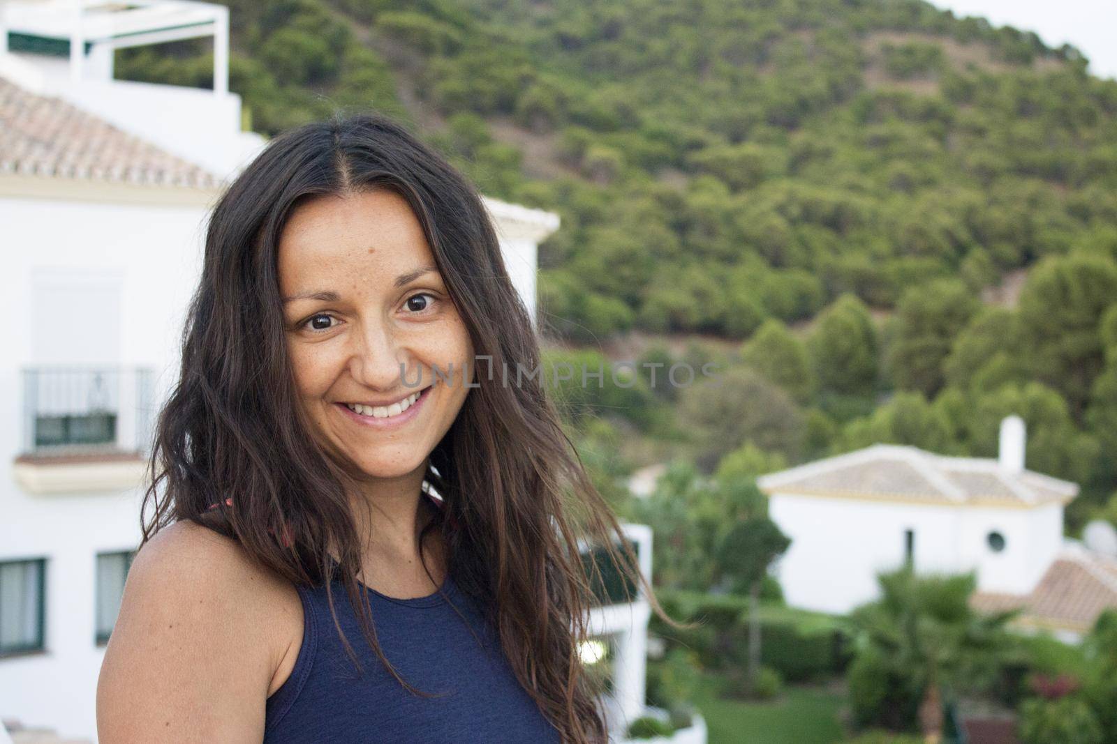 Portrait of youthful woman on mountain background. Smiling.