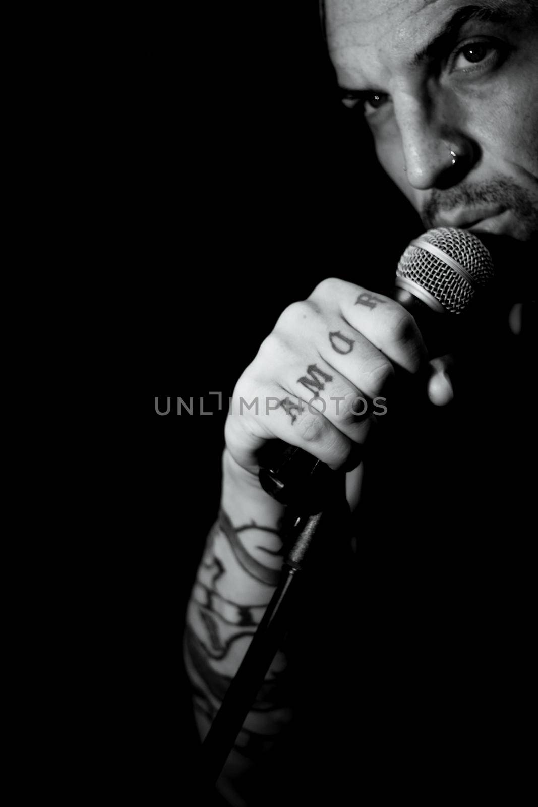 Singer man with round microphone on dark background by GemaIbarra