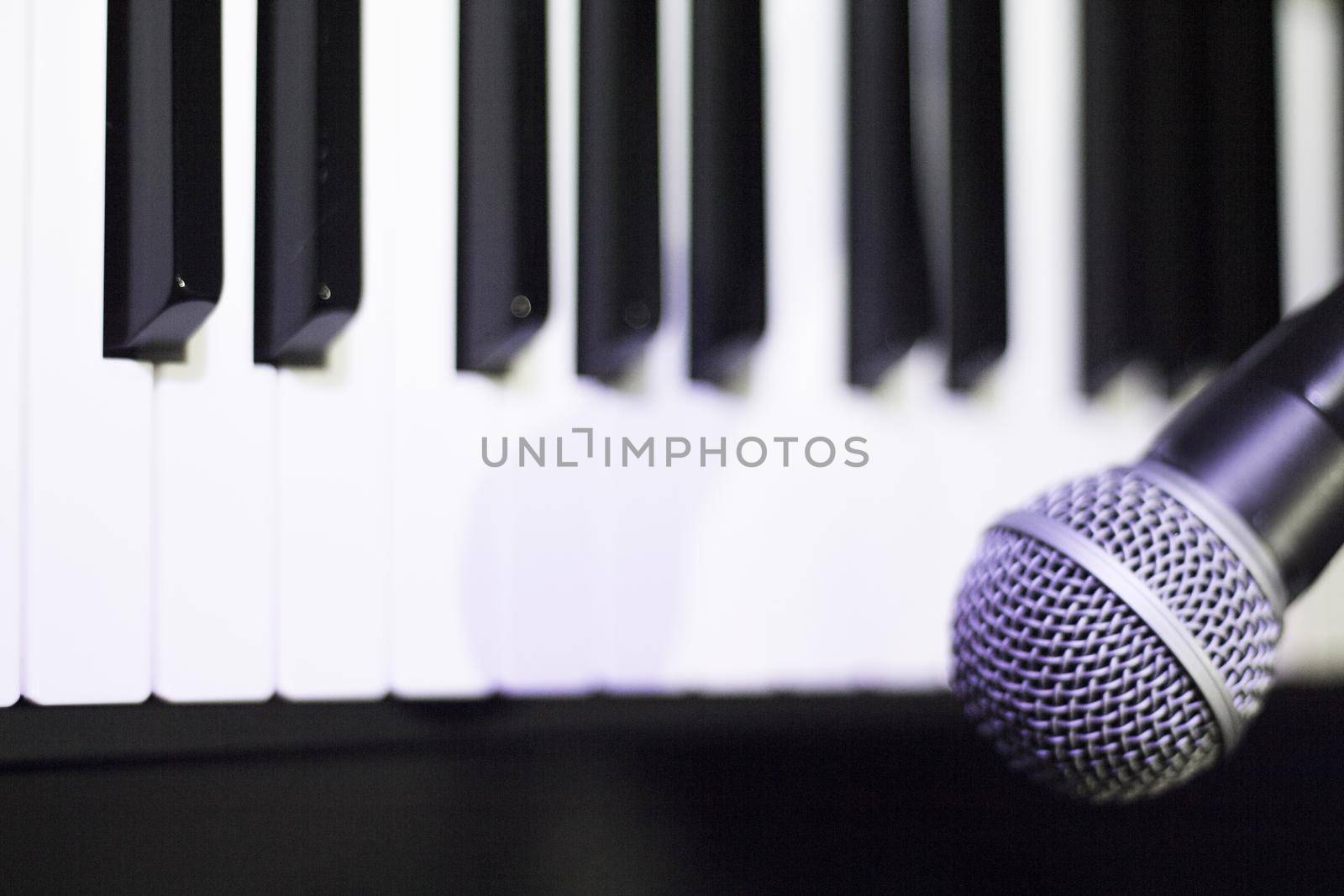 Microphone over piano keys in dim light by GemaIbarra